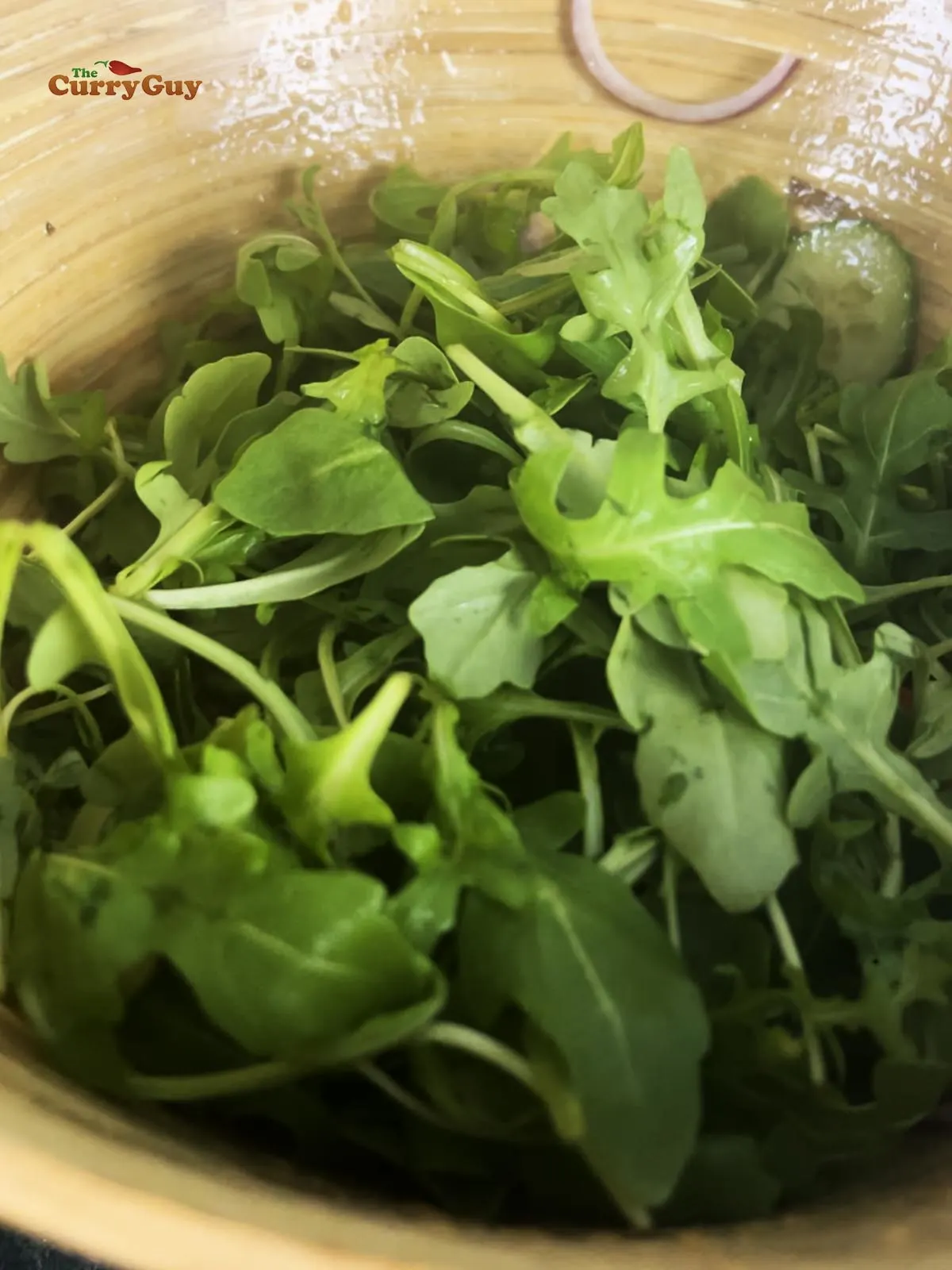 Adding the leafy greens to the salad