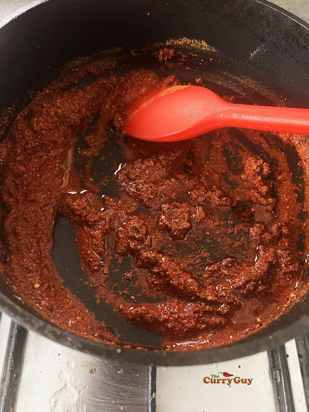 Adding the oil and stirring it into the water and tandoori masala powder.