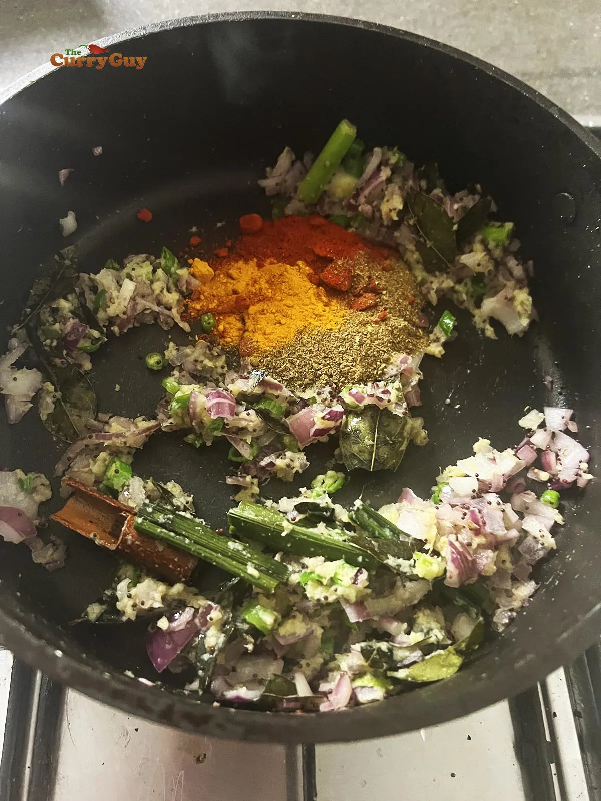 Adding ground spices to the pan. 