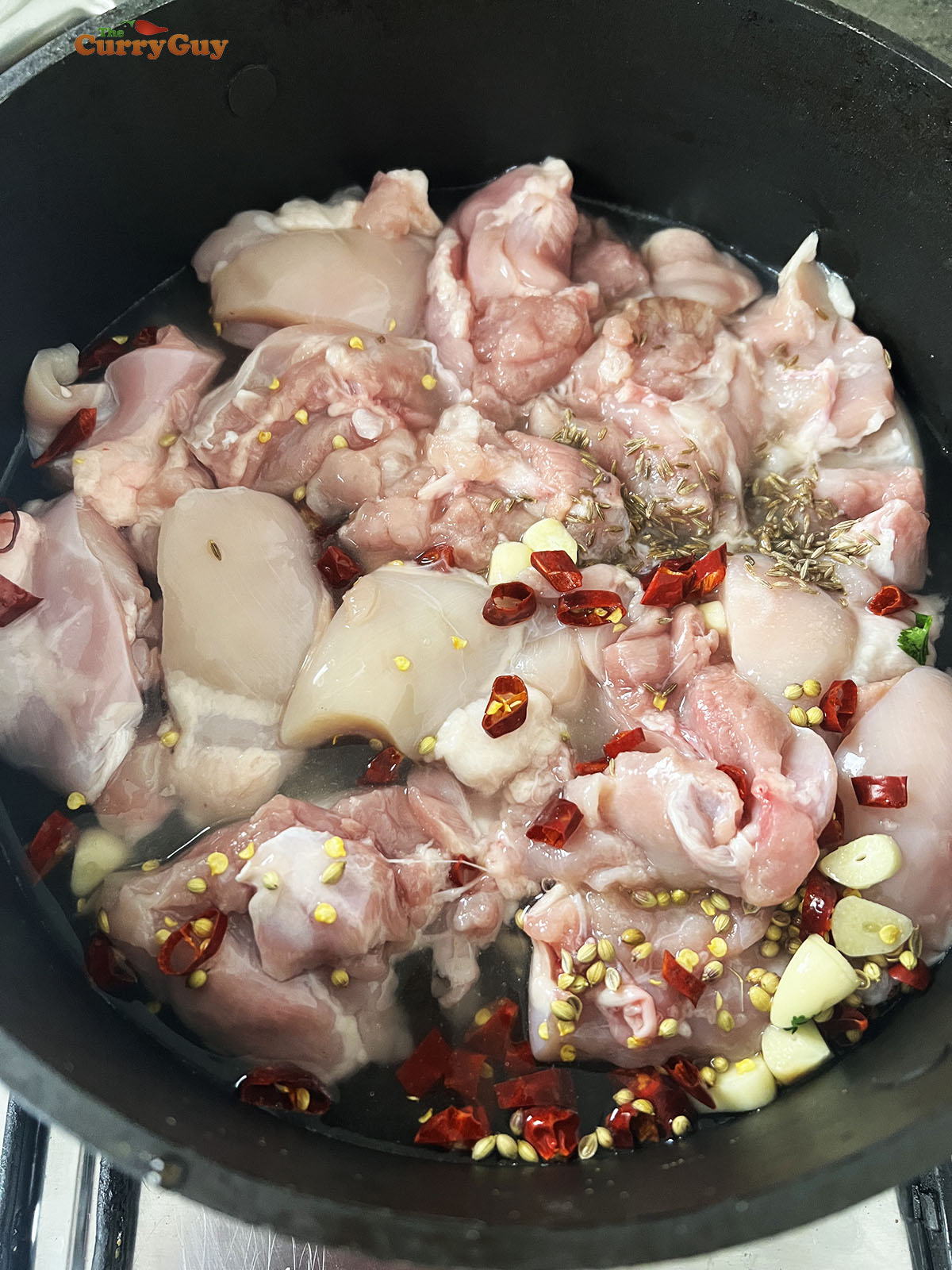 Simmering the chicken with the aromatic ingredients.