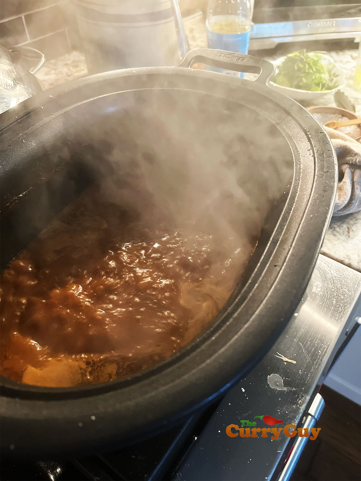Simmering the beef in the pan with the paste and stock.