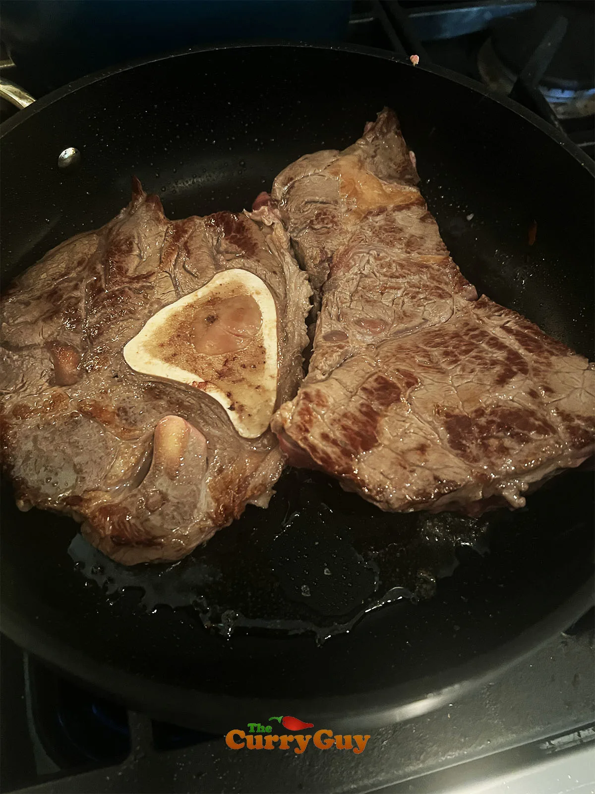Searing the beef in a hot pan.