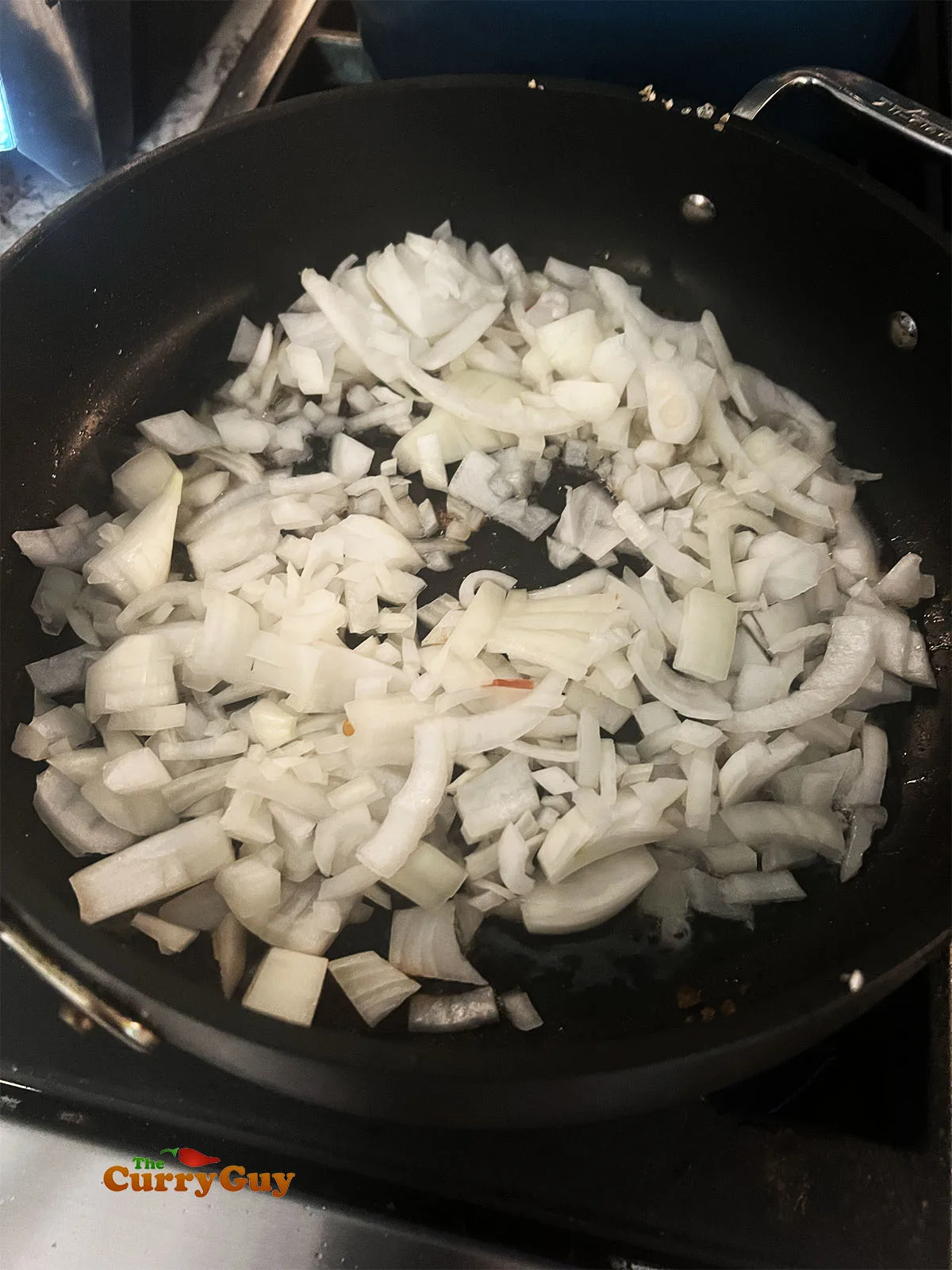 Frying the onions, garlic and spices in a pan.