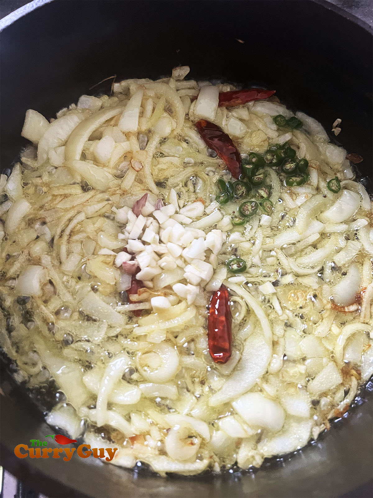 Adding the chopped onions to fry.