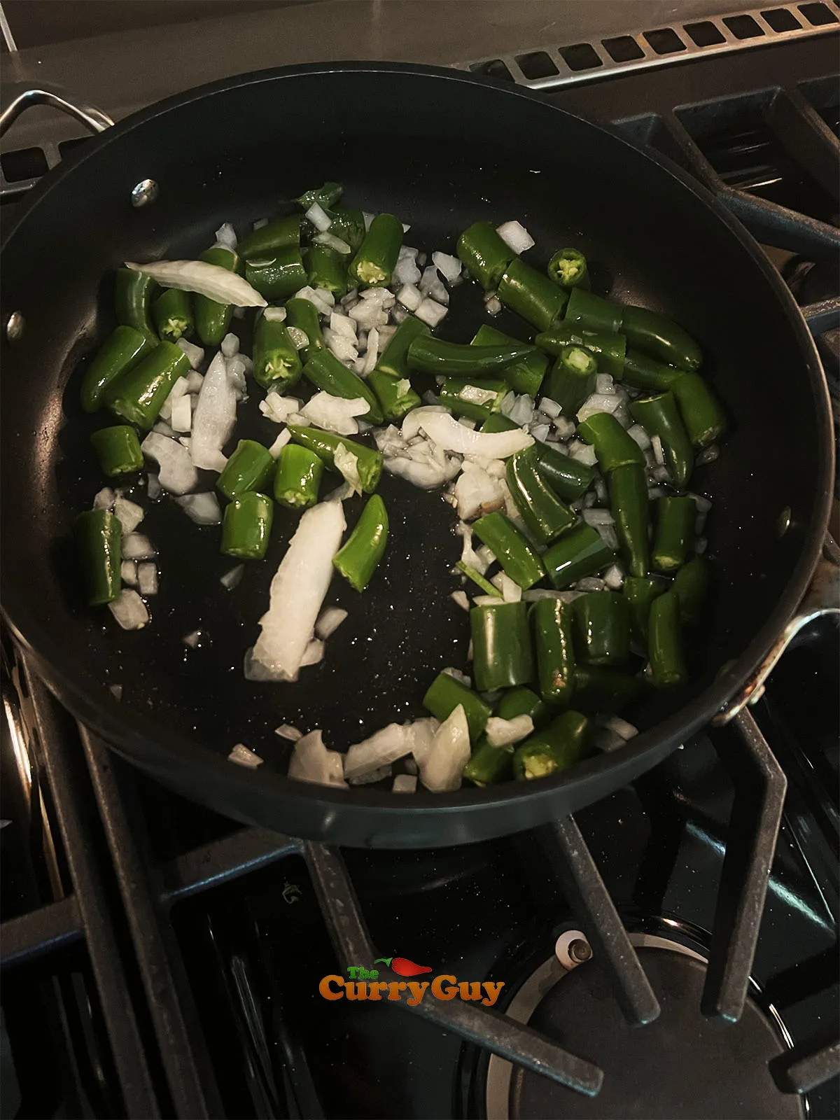 Frying the chilies and onion in olive oil.