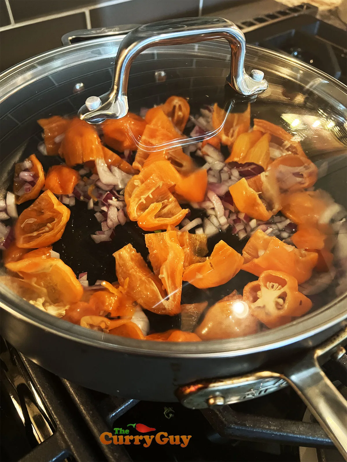 Frying the habanero chilies, garlic and onion in olive oil.