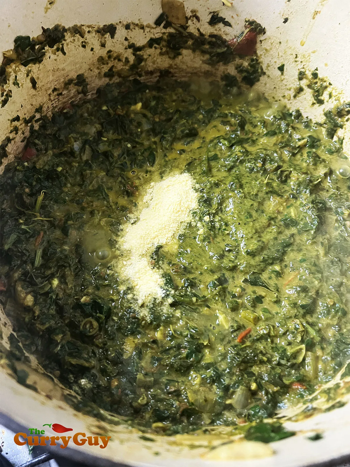 Finishing off the saag recipe by adding ghee, corn meal and salt.