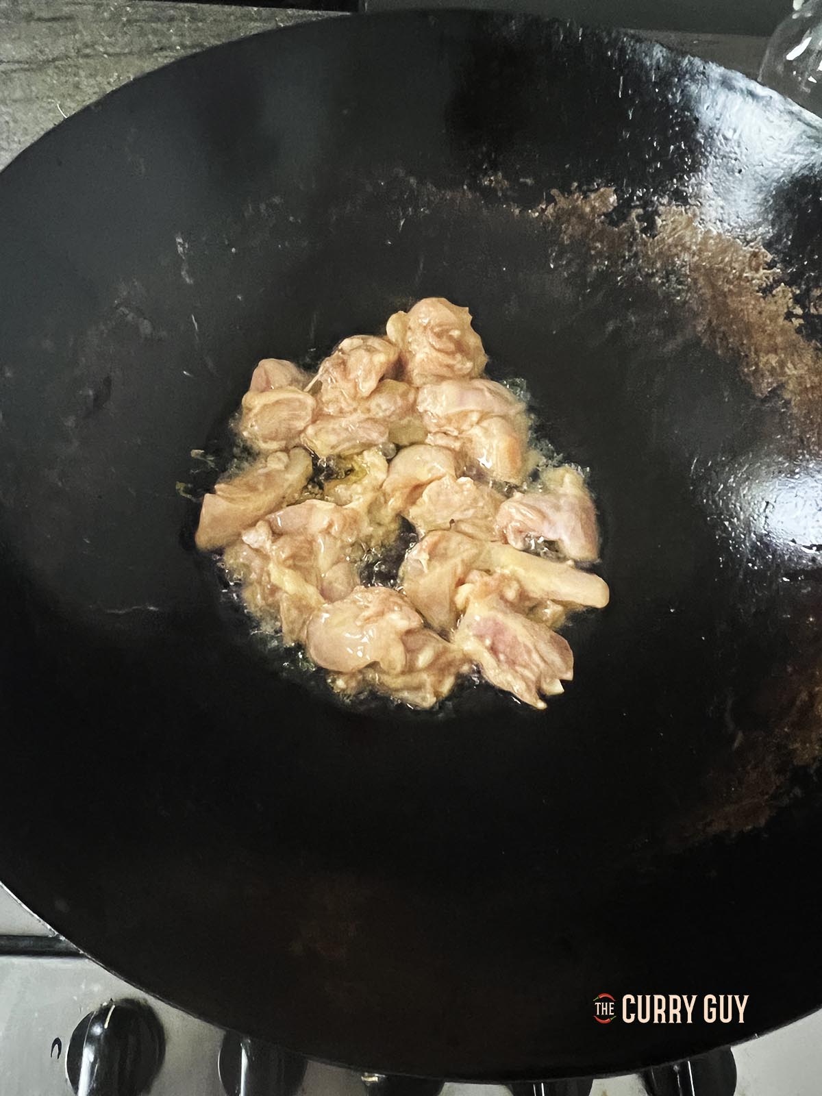 Frying the chicken in a wok.