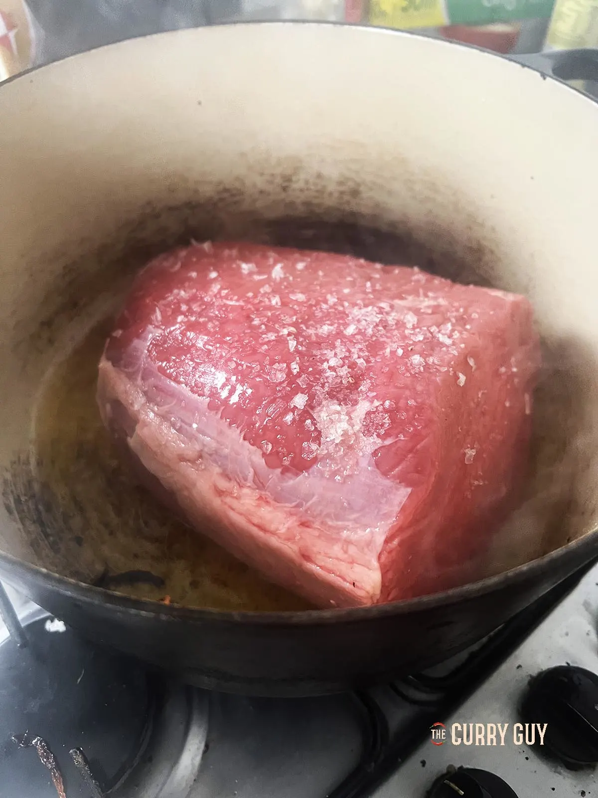 Searing the meat in ghee in the pot.