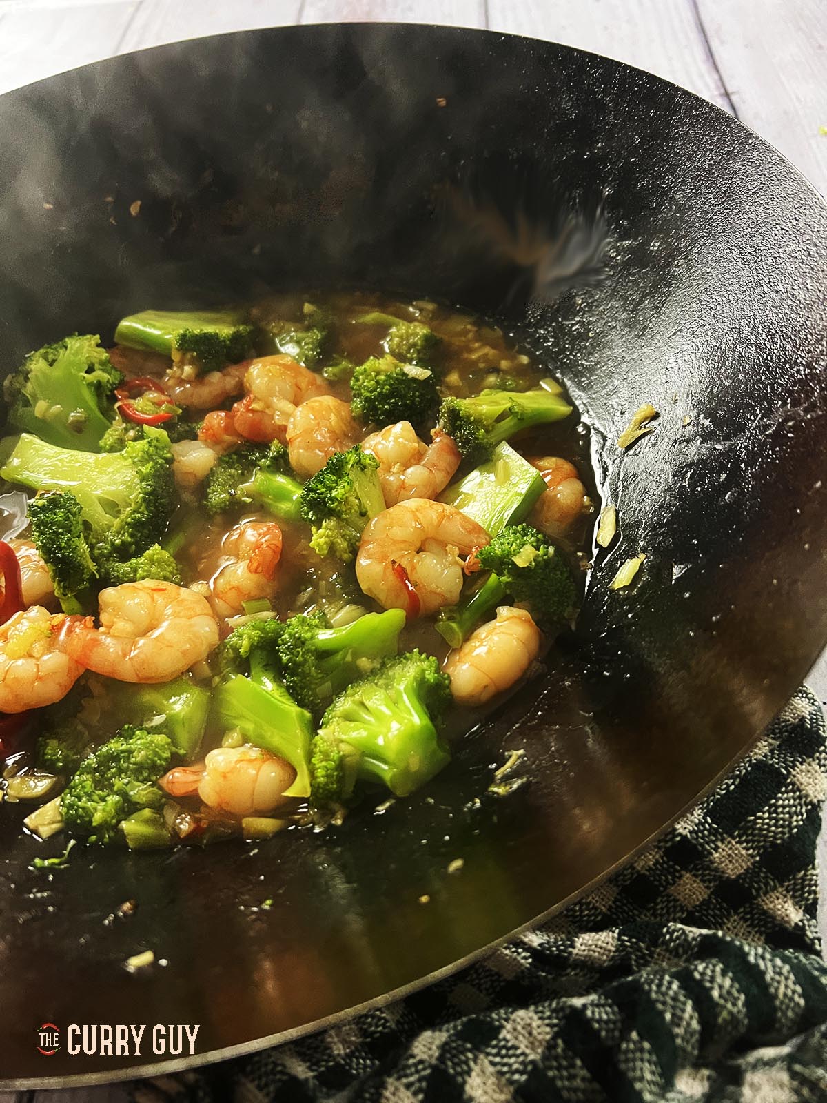 Shrimp and broccoli stir fry served at the table.