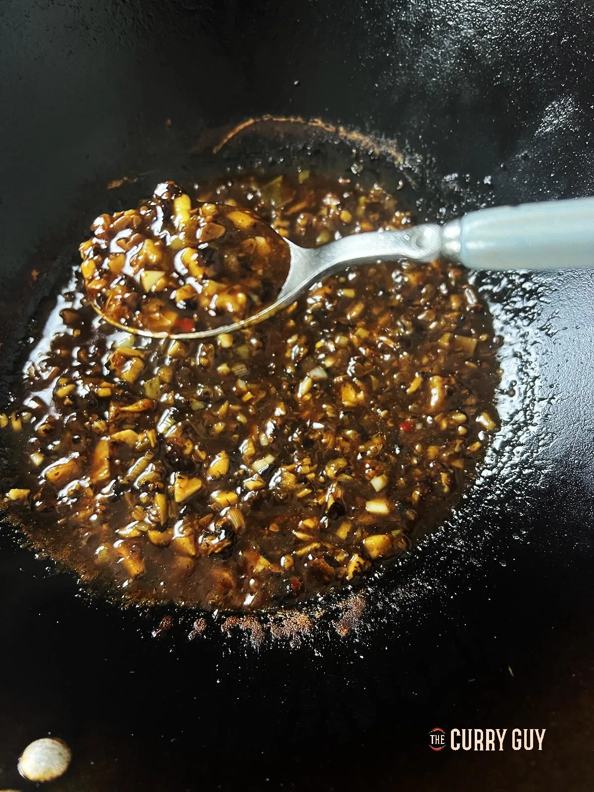 A spoonful of the black finished black beans sauce.