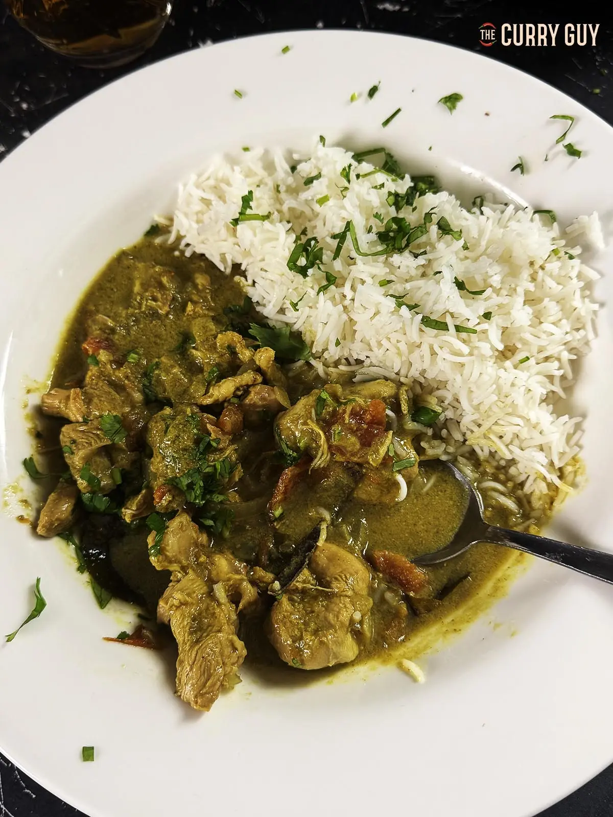 Slow Cooker Chicken Curry on a plate with a side of white Basmati rice.