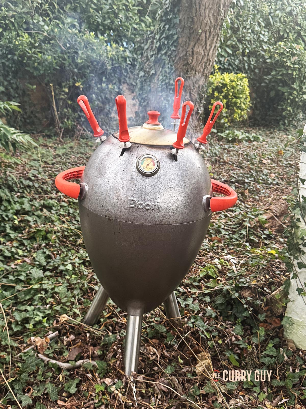 The tandoor with the lid on cooking the chicken.