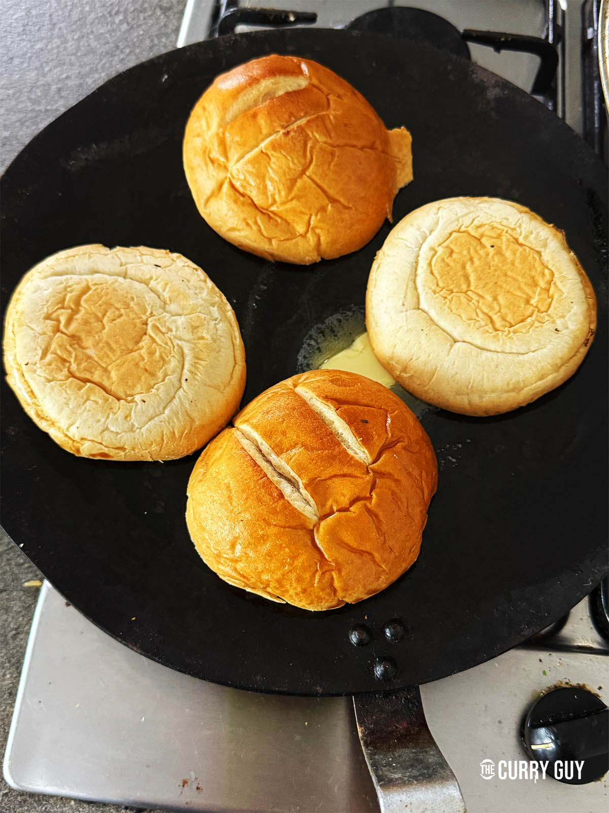 toasting the buns in butter on a tawa.