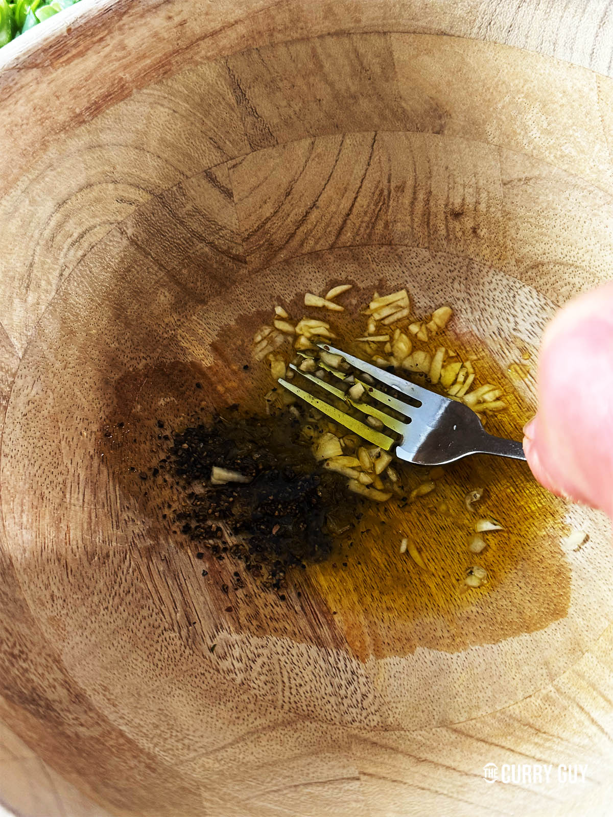 Préparation de la vinaigrette avec de l'huile d'olive, du jus de citron, de l'ail, du sel et du poivre.