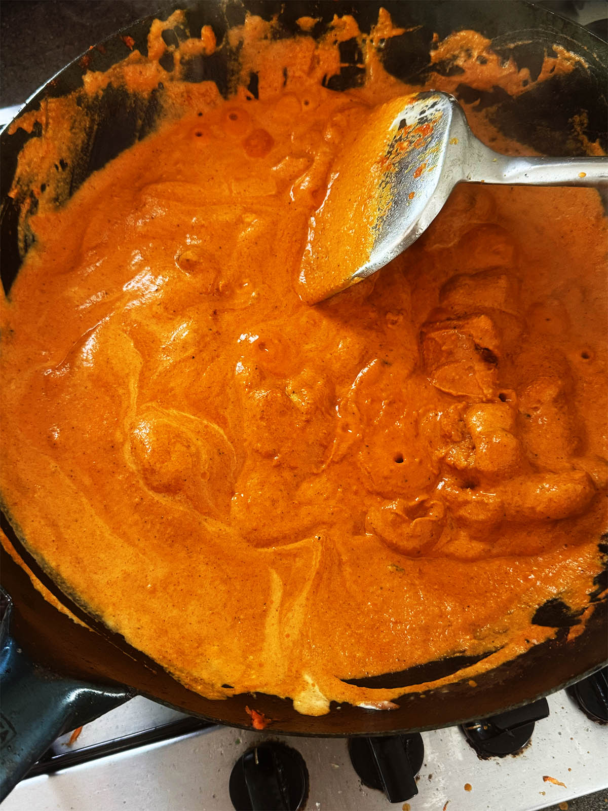 The blended butter chicken sauce in a karahi.