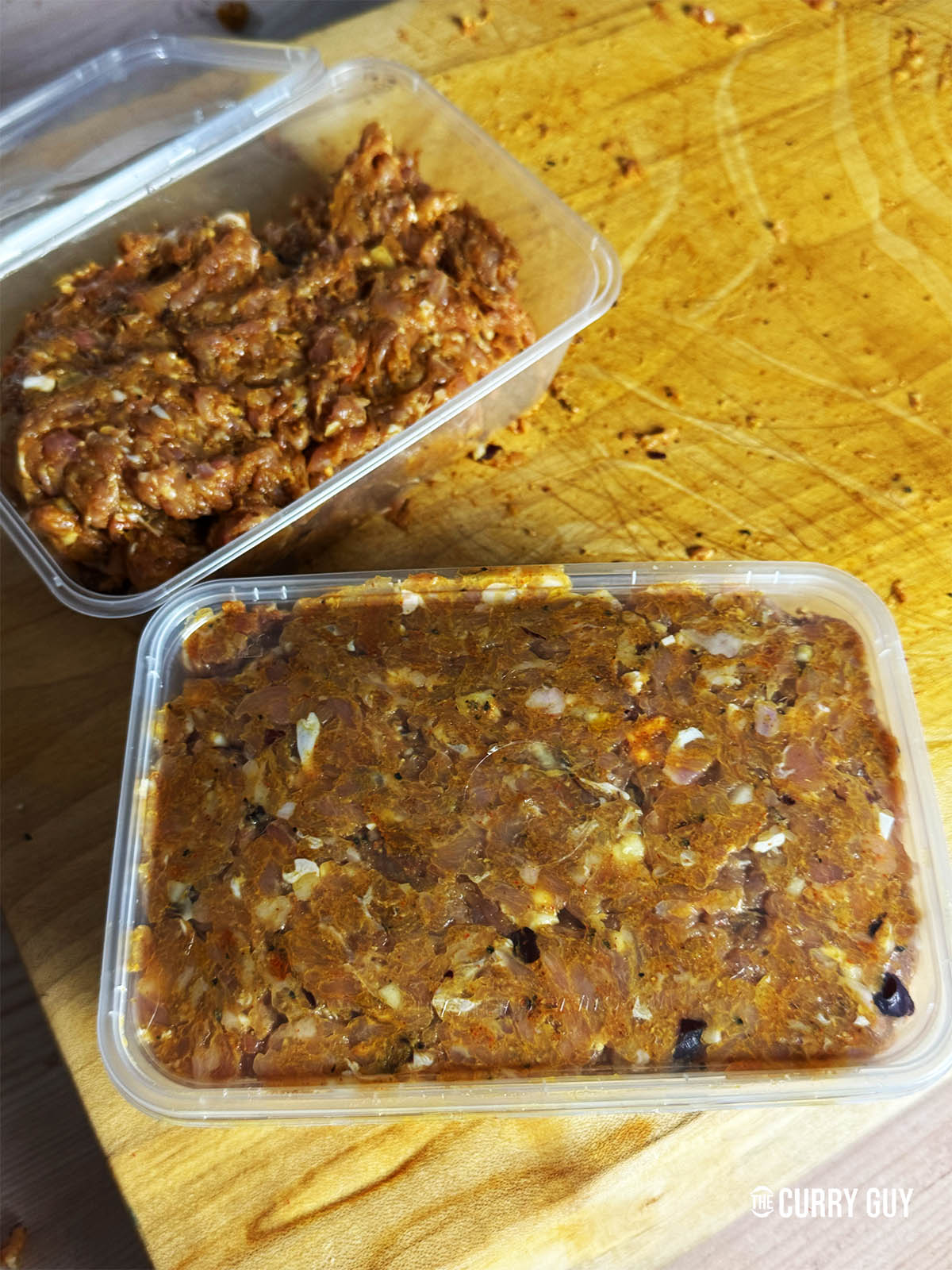 Placing the prepared kebab chicken meat in containers to marinate in the fridge for about an hour.