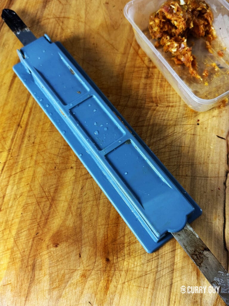 Bring the mould down on the meat to form it into a kebab.