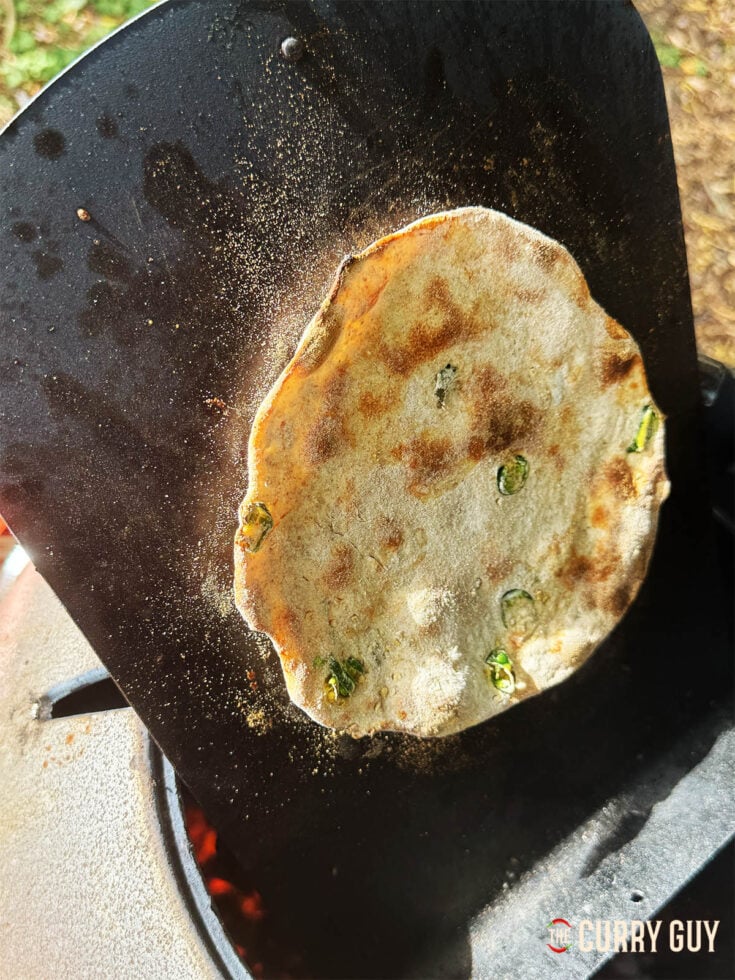 Tandoori roti with chilli and garlic on a naan pan cooking in the Doori tandoor oven.