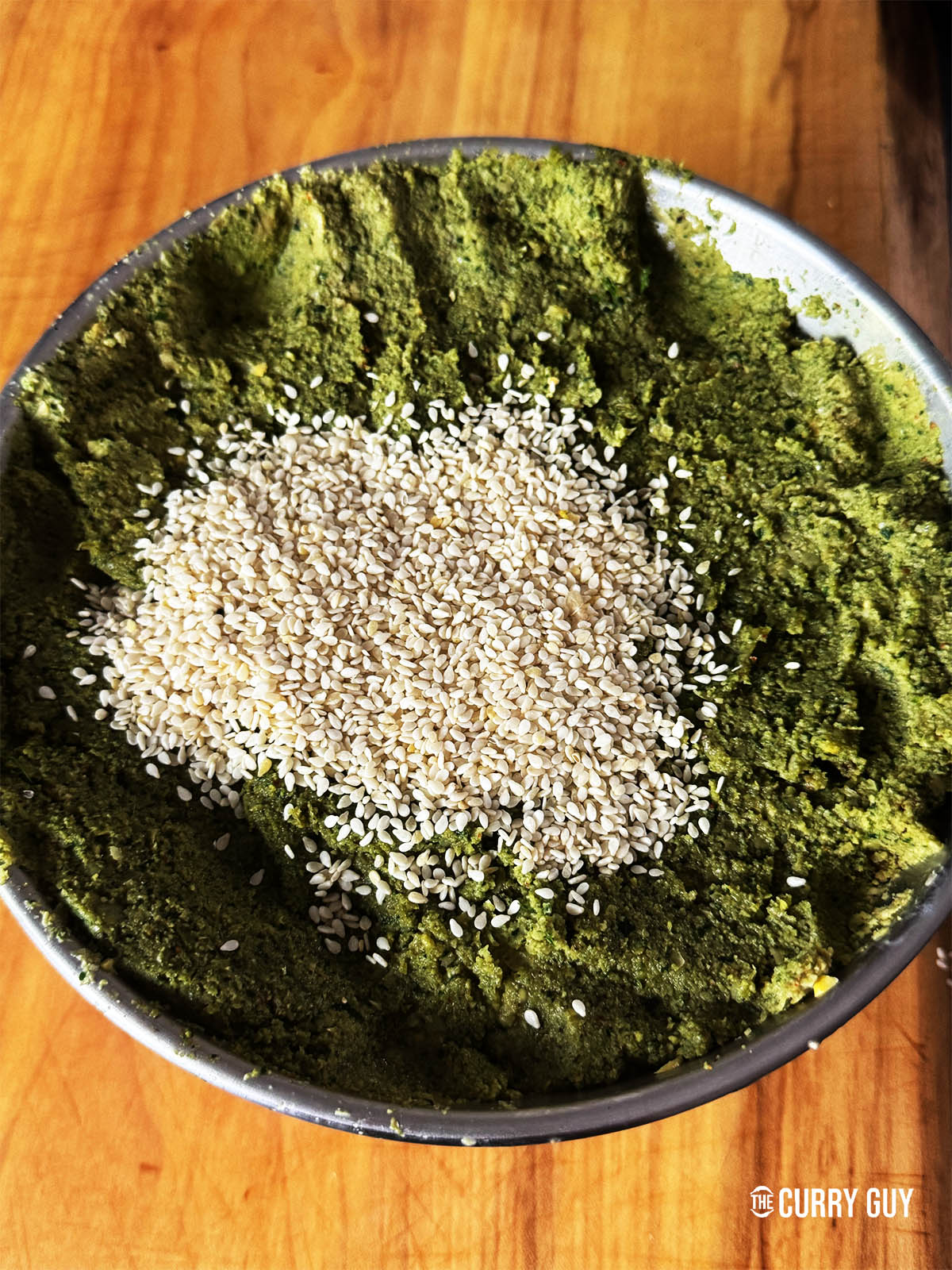 Adding the sesame seeds to the felafel paste.