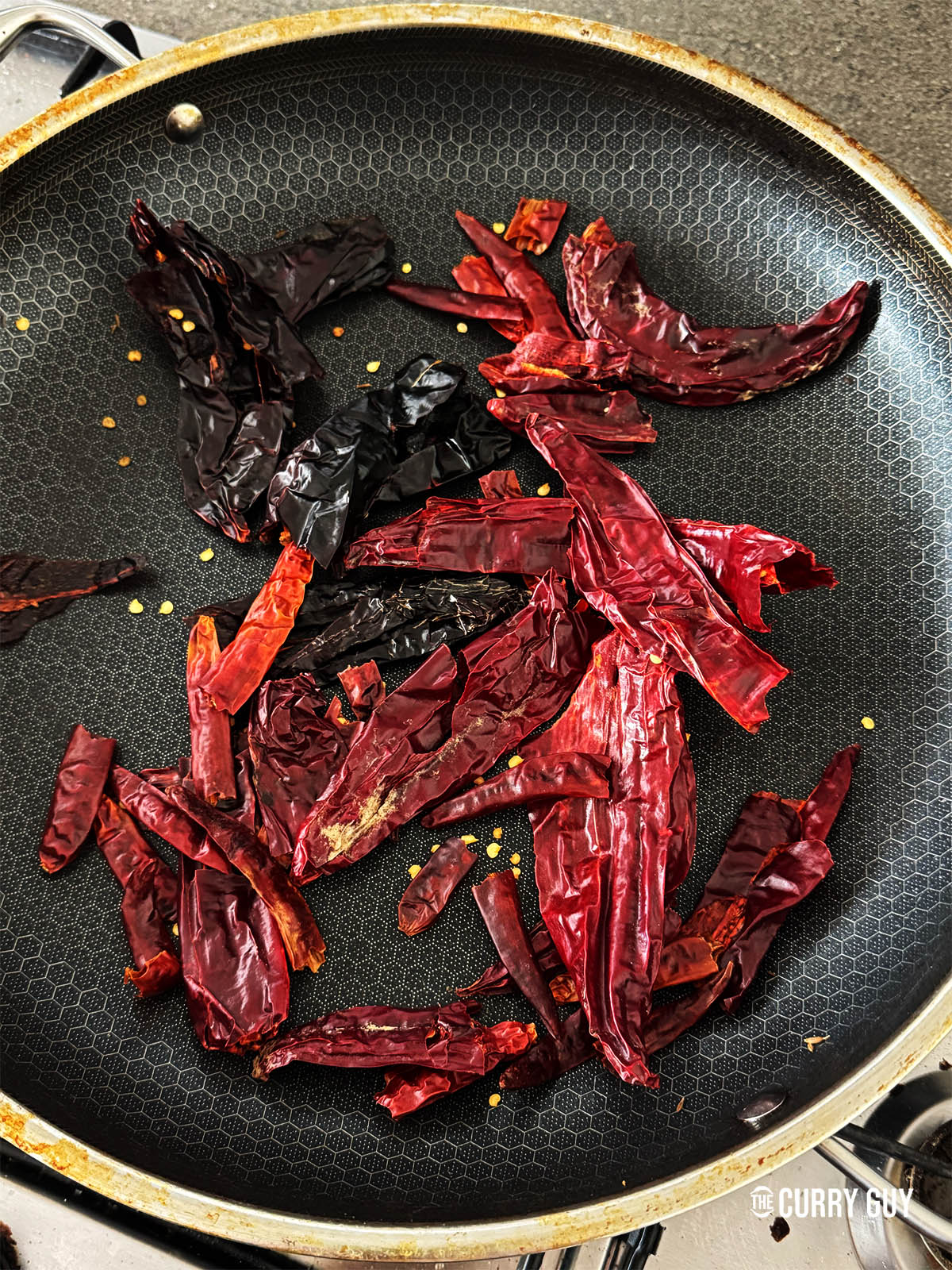 Toasting the dried chillies in a pan over a medium heat.
