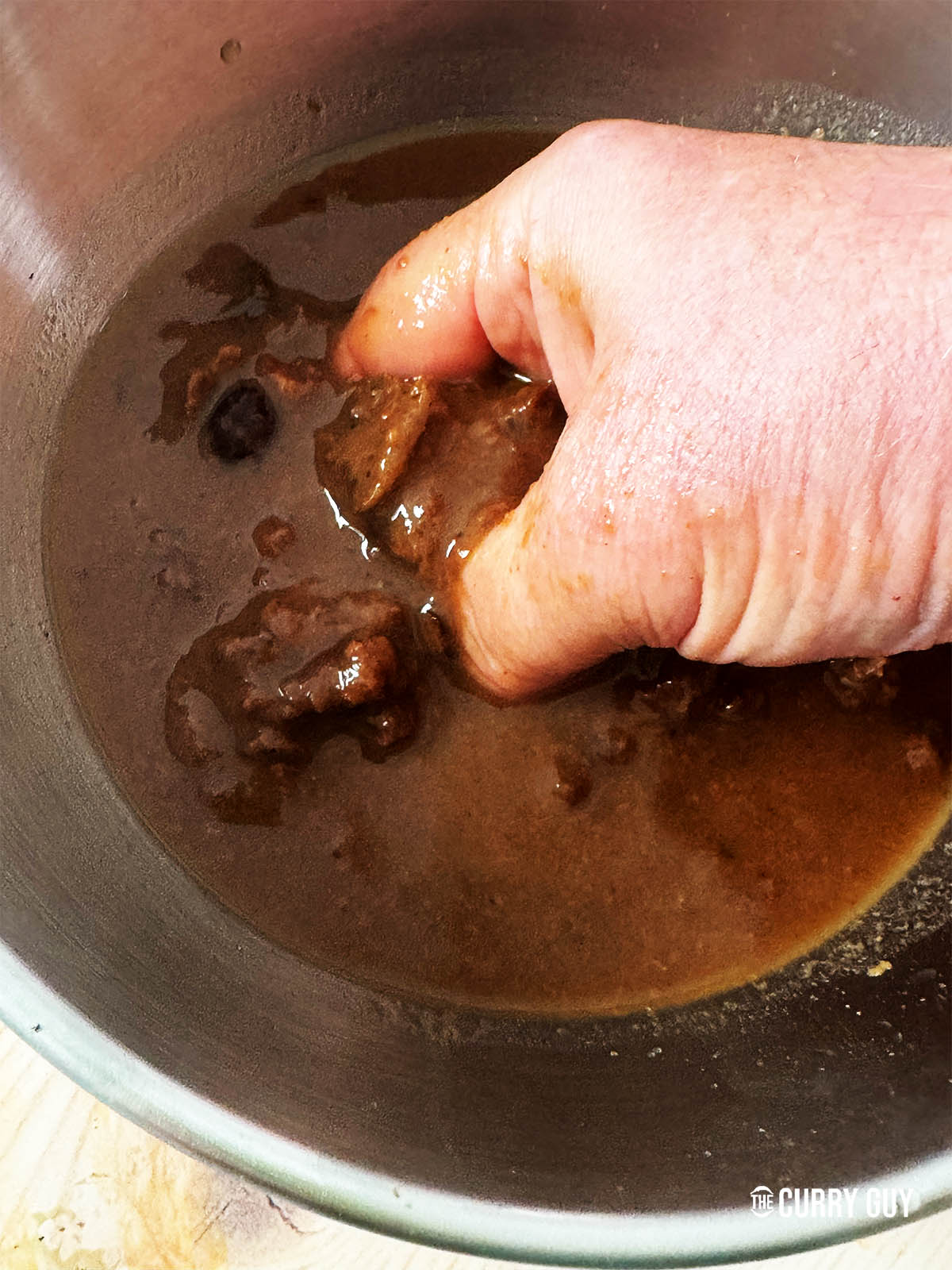Breaking the block tamarind up by hand after soaking for 2 hours.