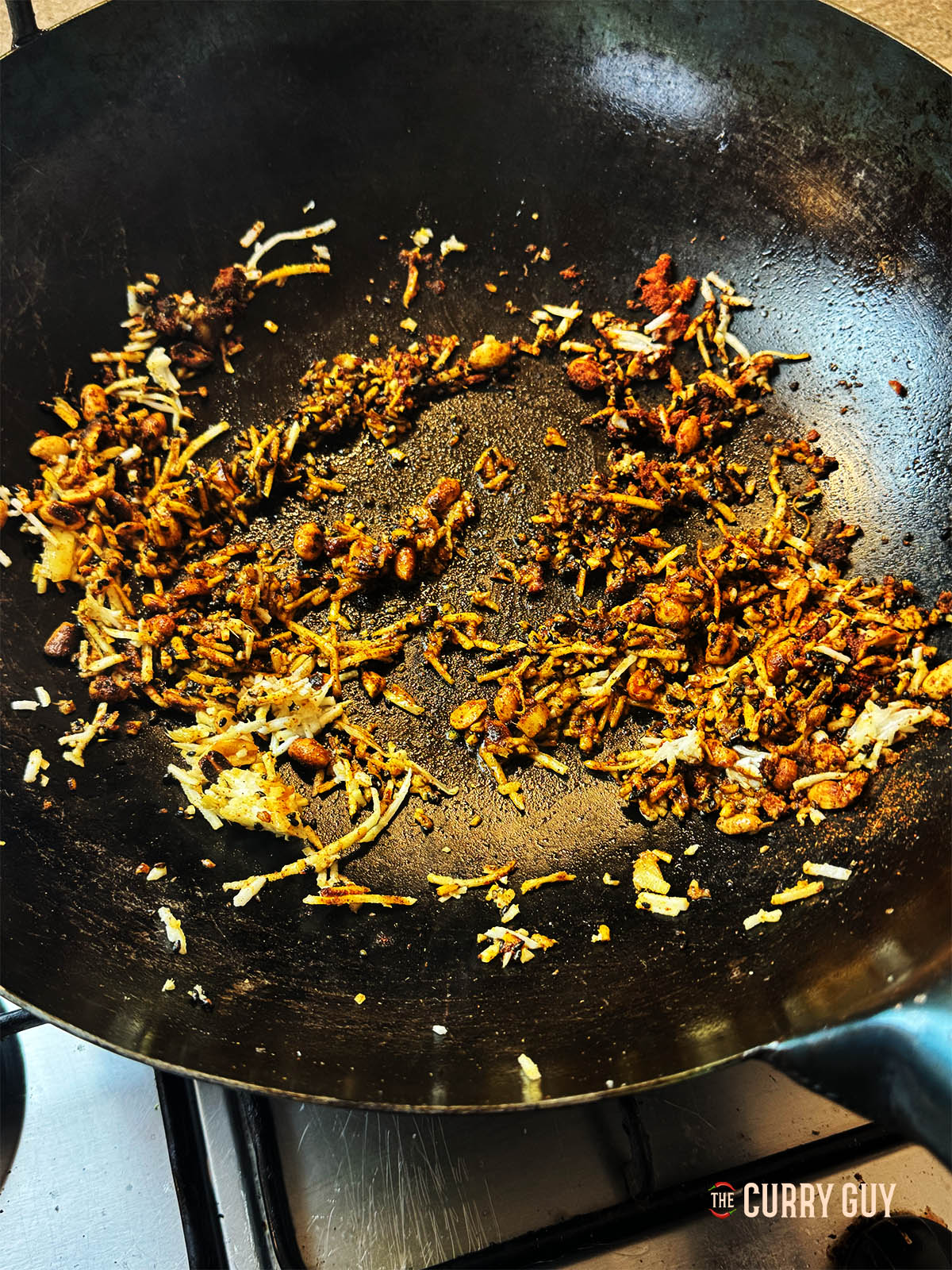 adding the onion, coconut and grated ginger to the pan.