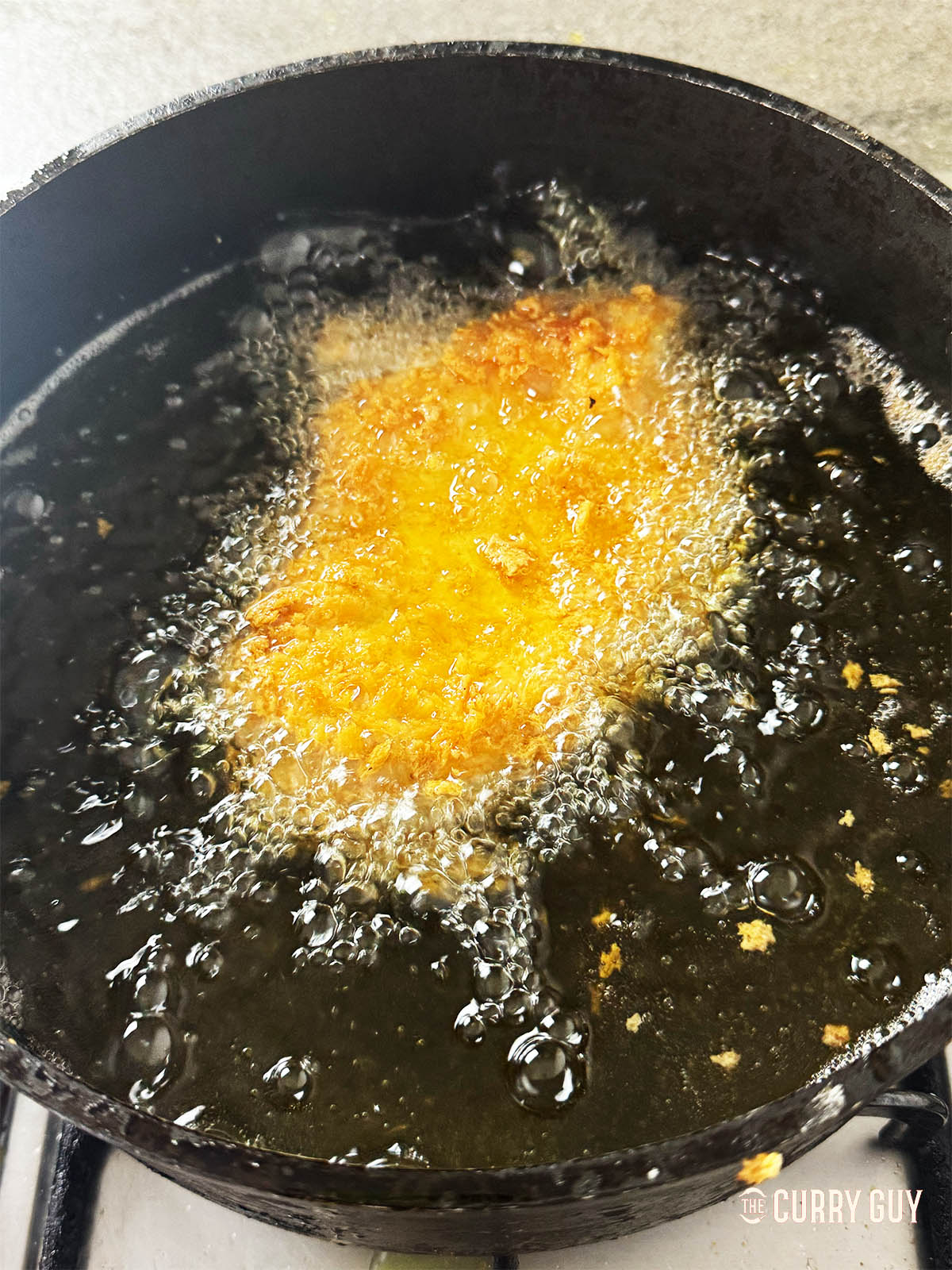 Frying a chicken breast in oil. 