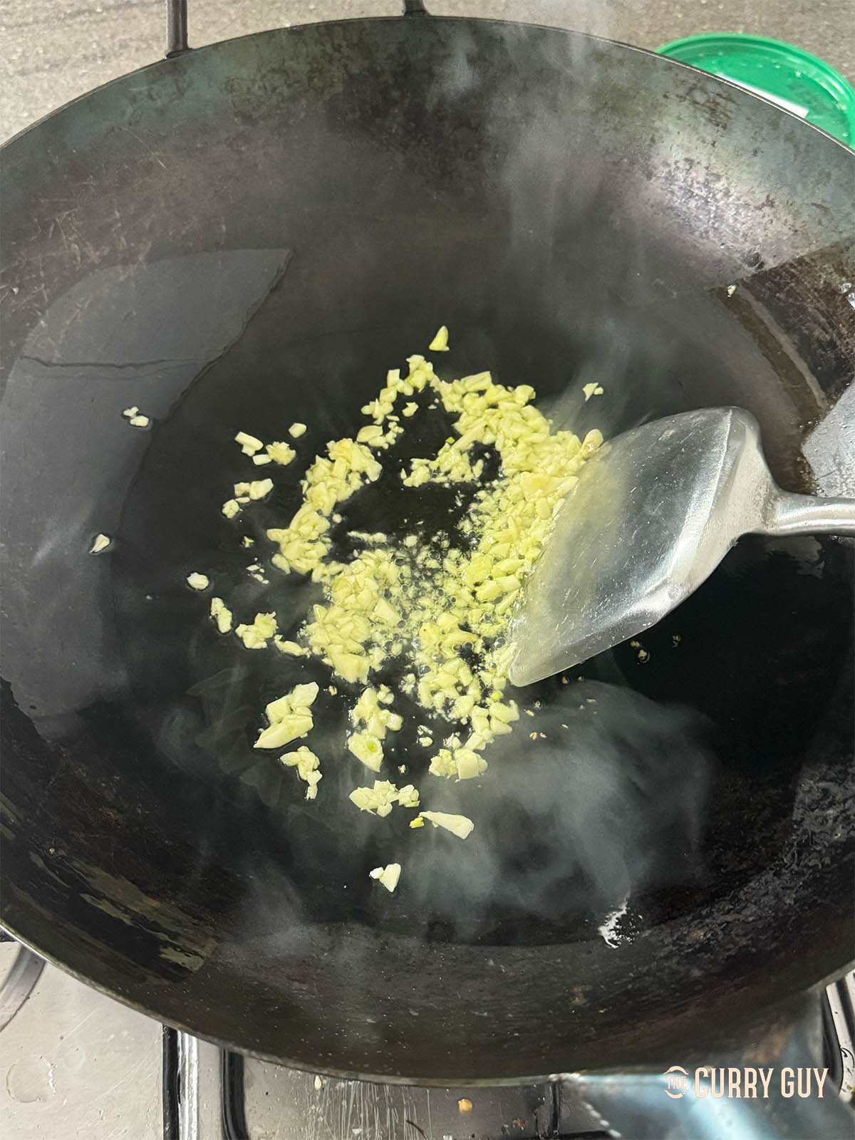 Frying roughly chopped garlic in oil.