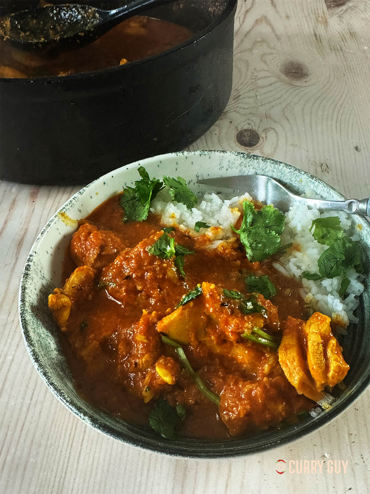 Curry de poulet à l'ail dans un bol de service avec du riz.