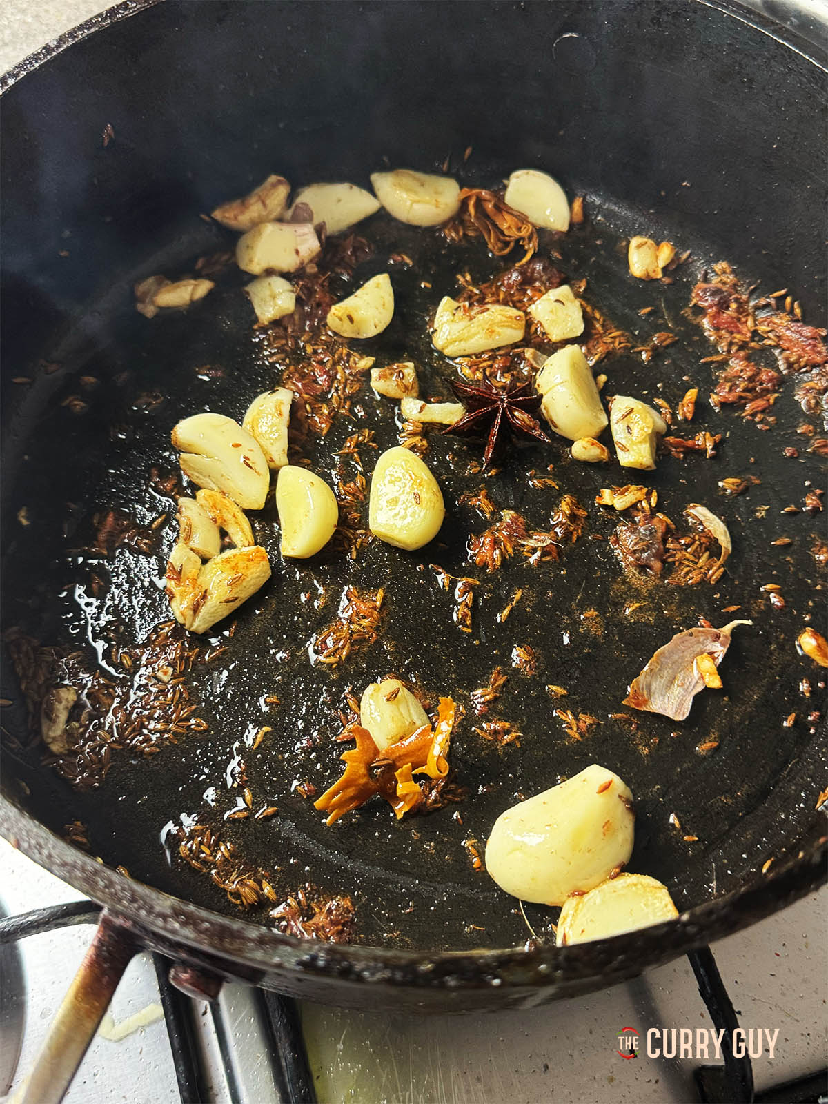 Ajout des anchois et de l'ail à la poêle pour rôtir l'ail et émietter les anchois.