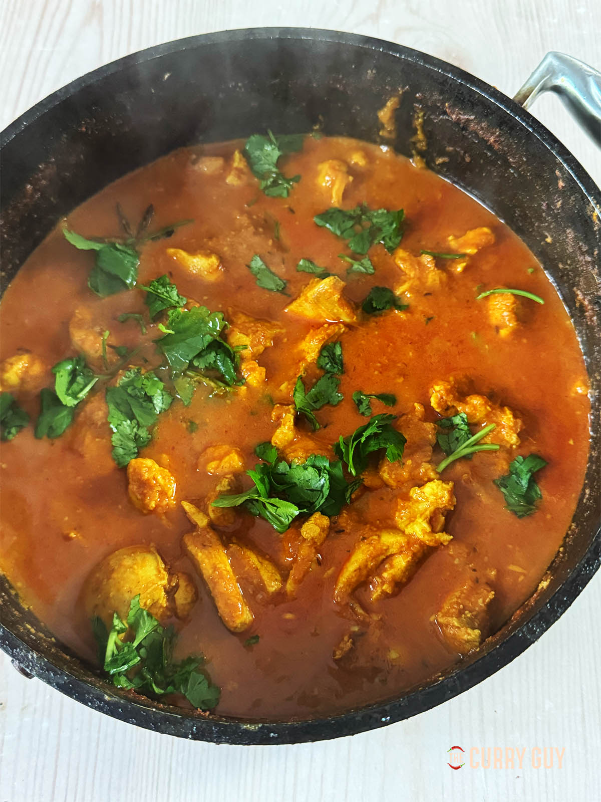 Le curry de poulet à l'ail fini garni de coriandre.