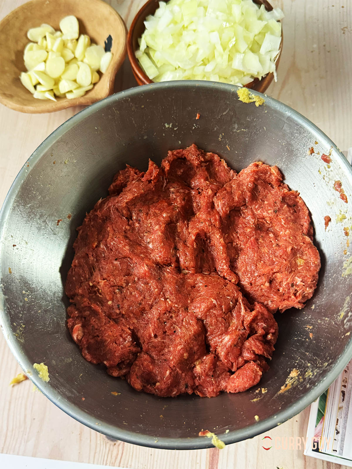 The meat and marinade ingredients all mixed up well in a mixing bowl.