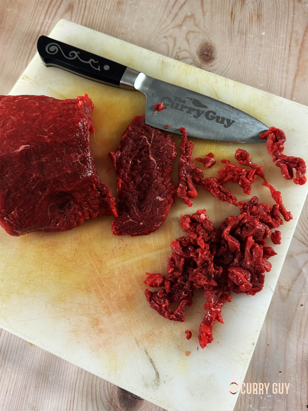 Slicing the meat as thinly as possible.