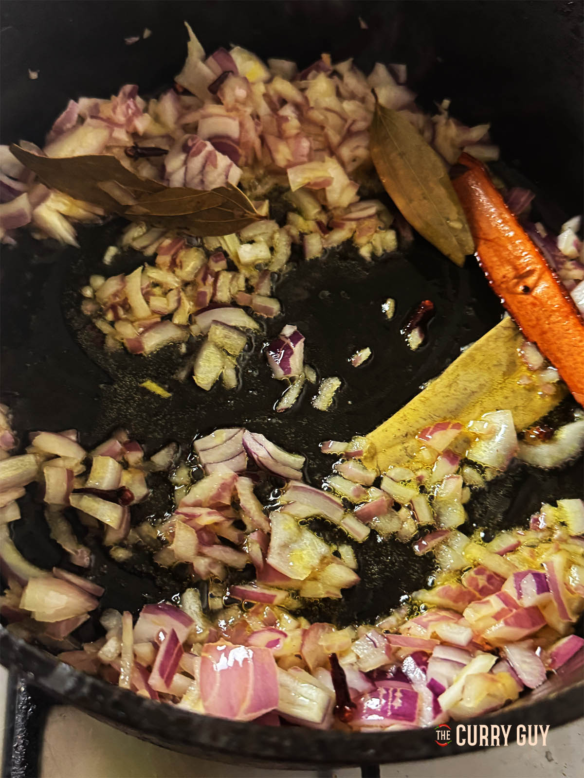 Frying the onions until soft in the butter and spices.