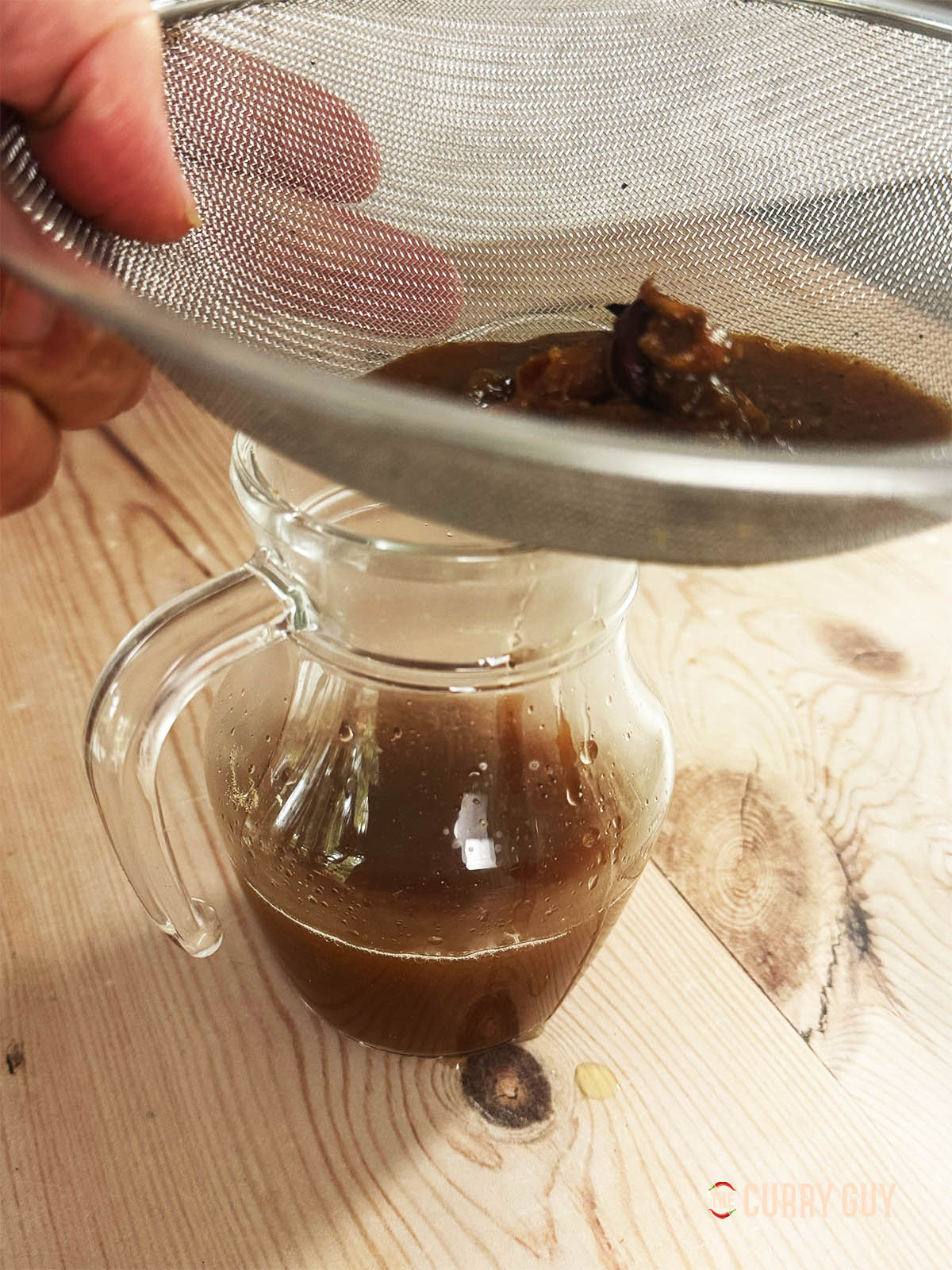 Running the tamarind water through a sieve.