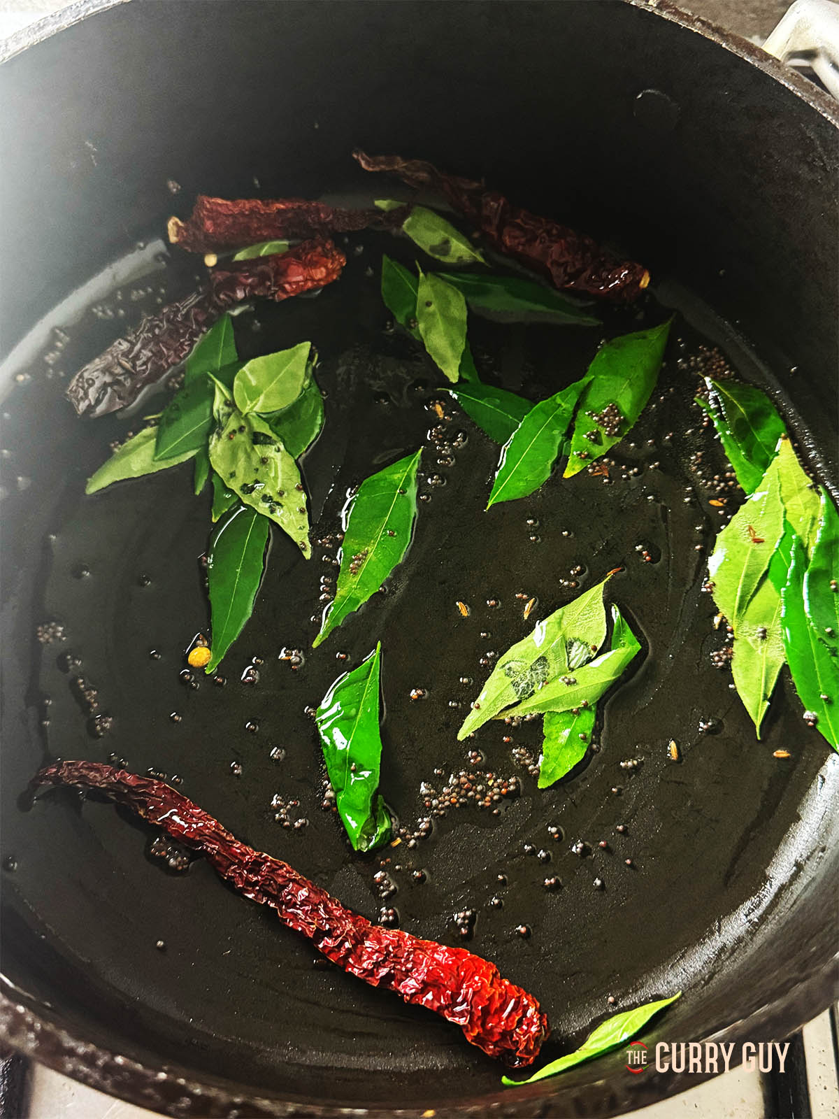 Stirring in the the curry leaves and Kashmiri chillies.