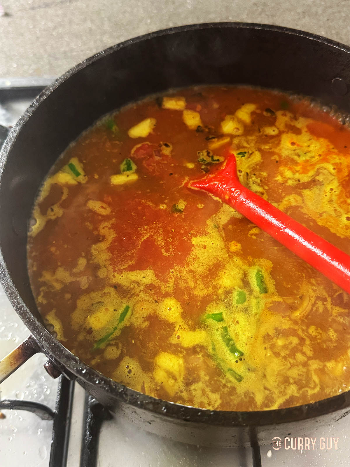 Adding the stock and tomatoes and bringing to a simmer. 