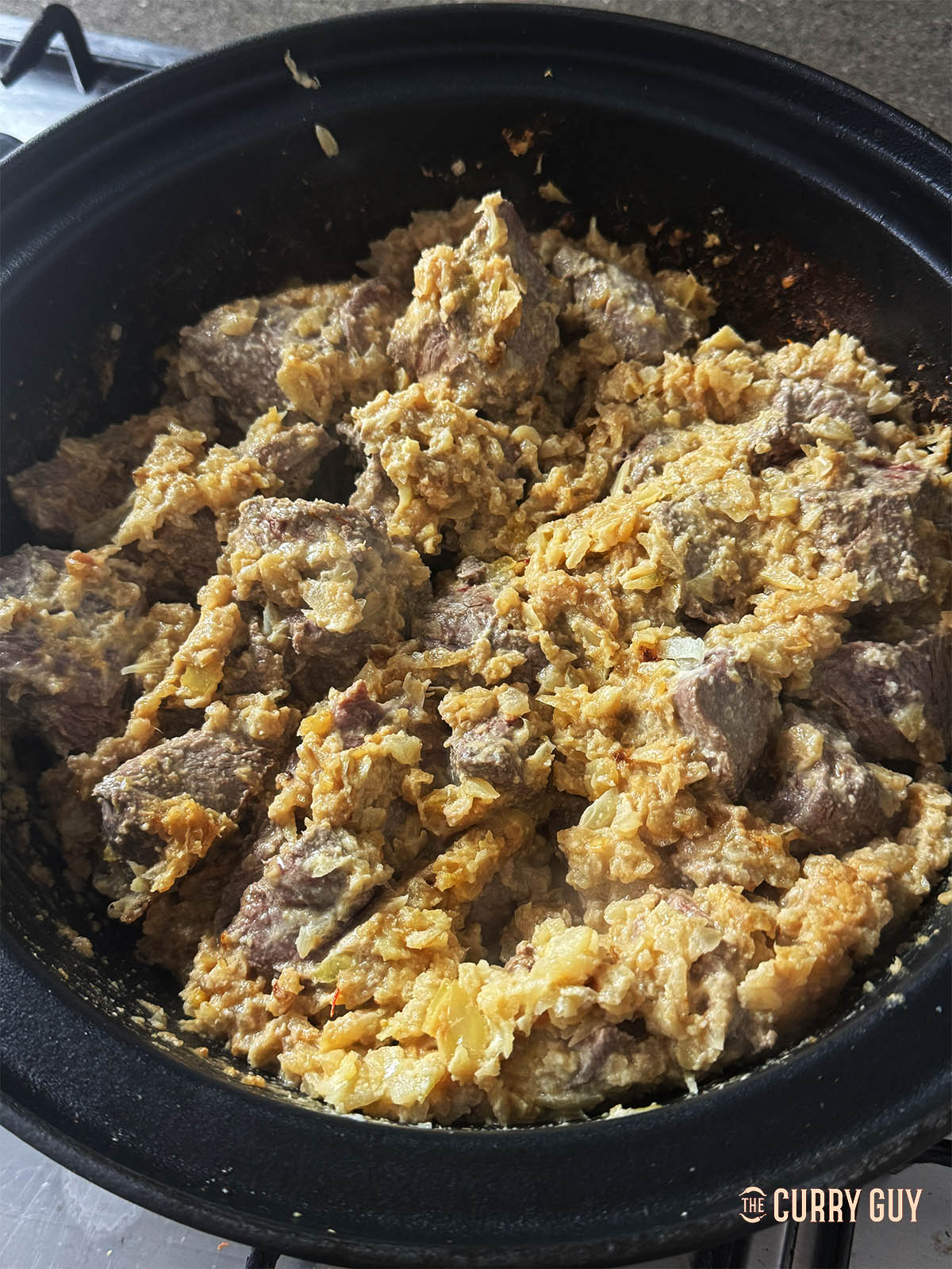 Adding the venison to the onions in the pan.