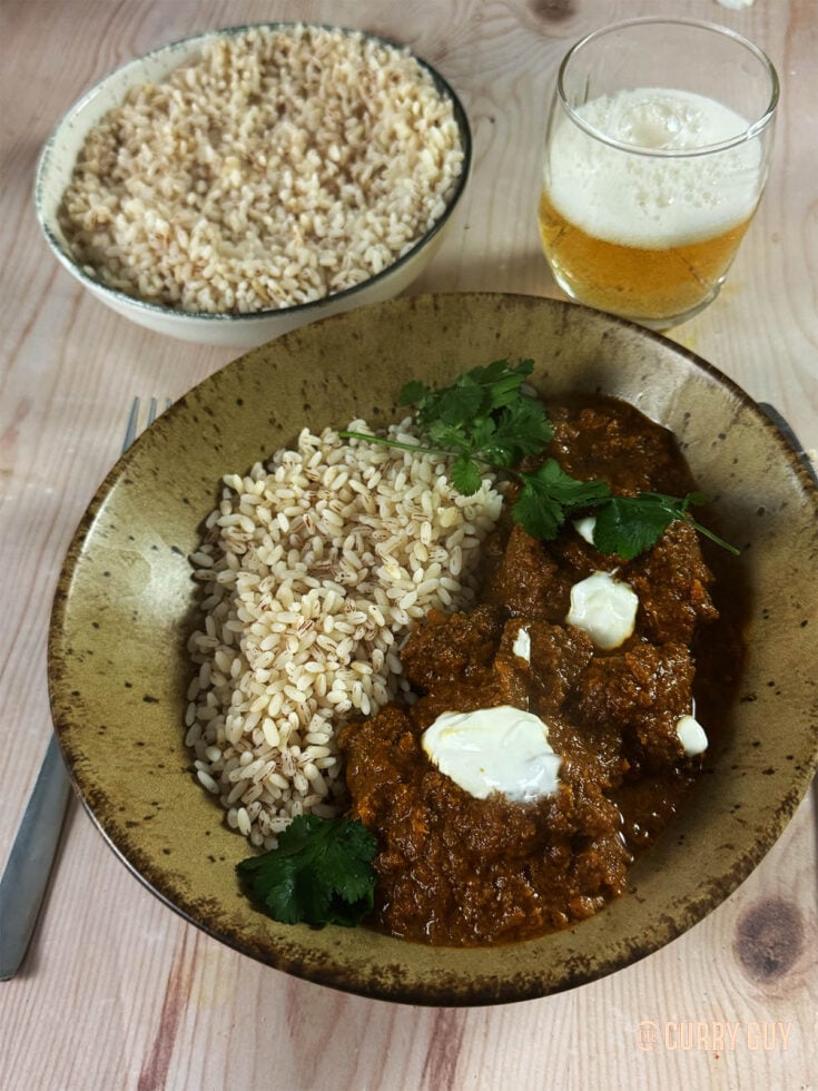 Venison curry in a serving bowl served with matta rice.