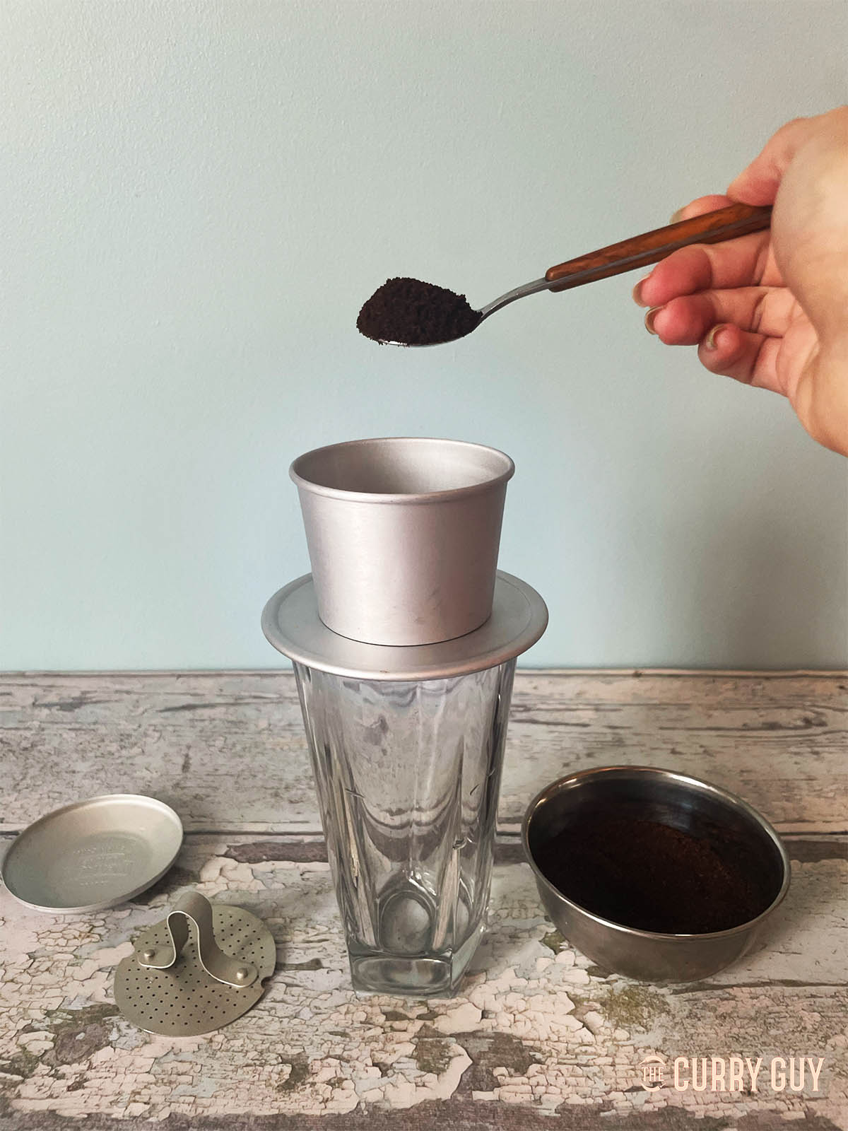 Adding ground coffee to a coffee filter for brewing. 