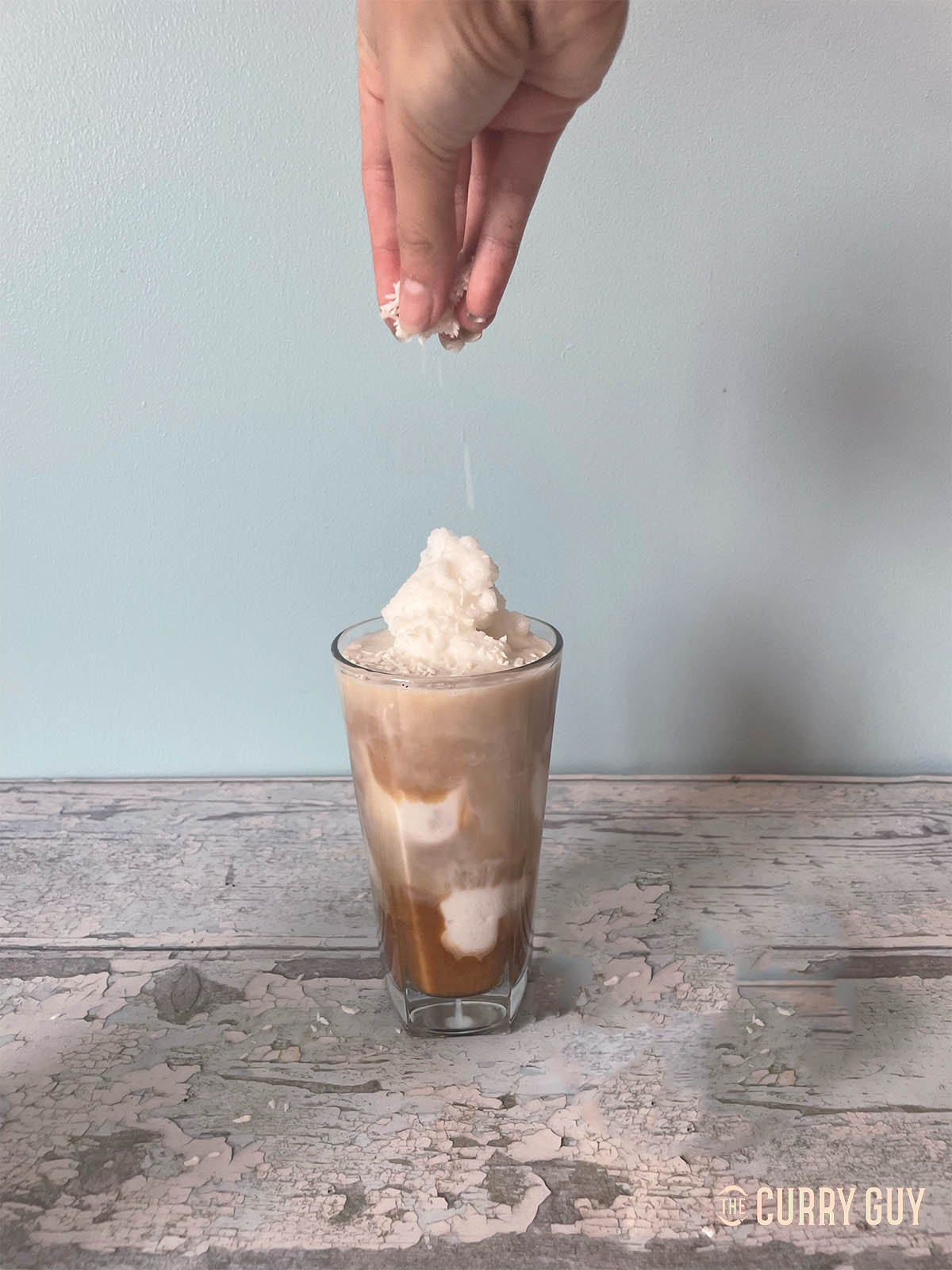 Topping the coconut coffee with coconut flakes.