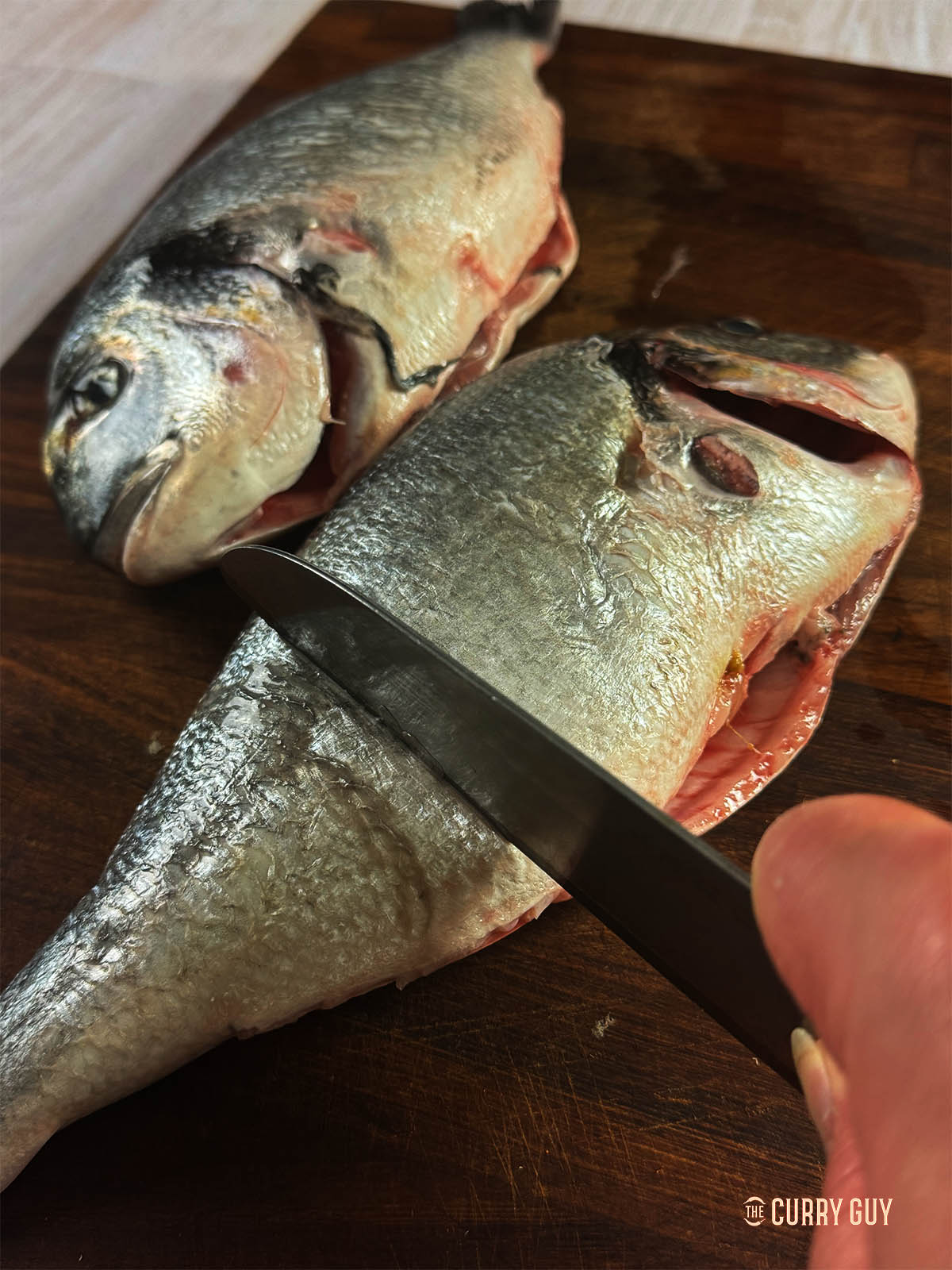 Scraping excess moisture from the skin of the fish.