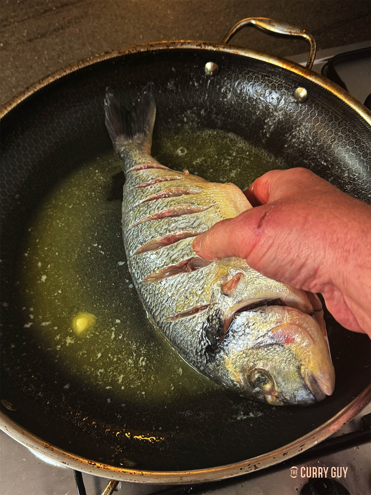 Dipping a fish in melted butter.