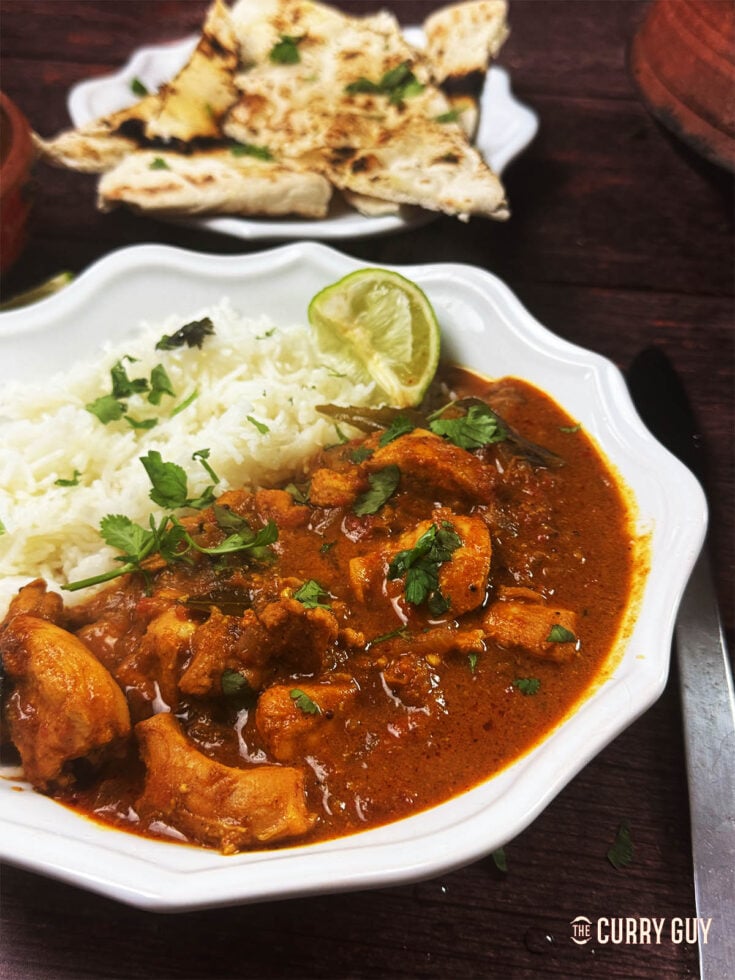 Chennai Chicken curry on a serving plate with rice.