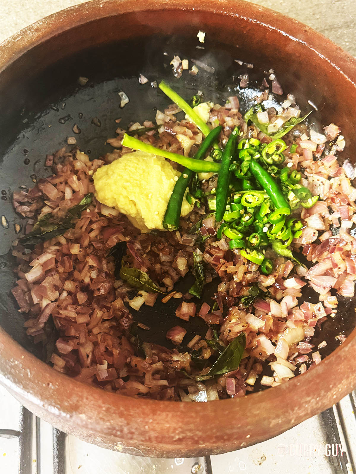 Frying the onions, chillies and adding the garlic and ginger paste and ground spices.