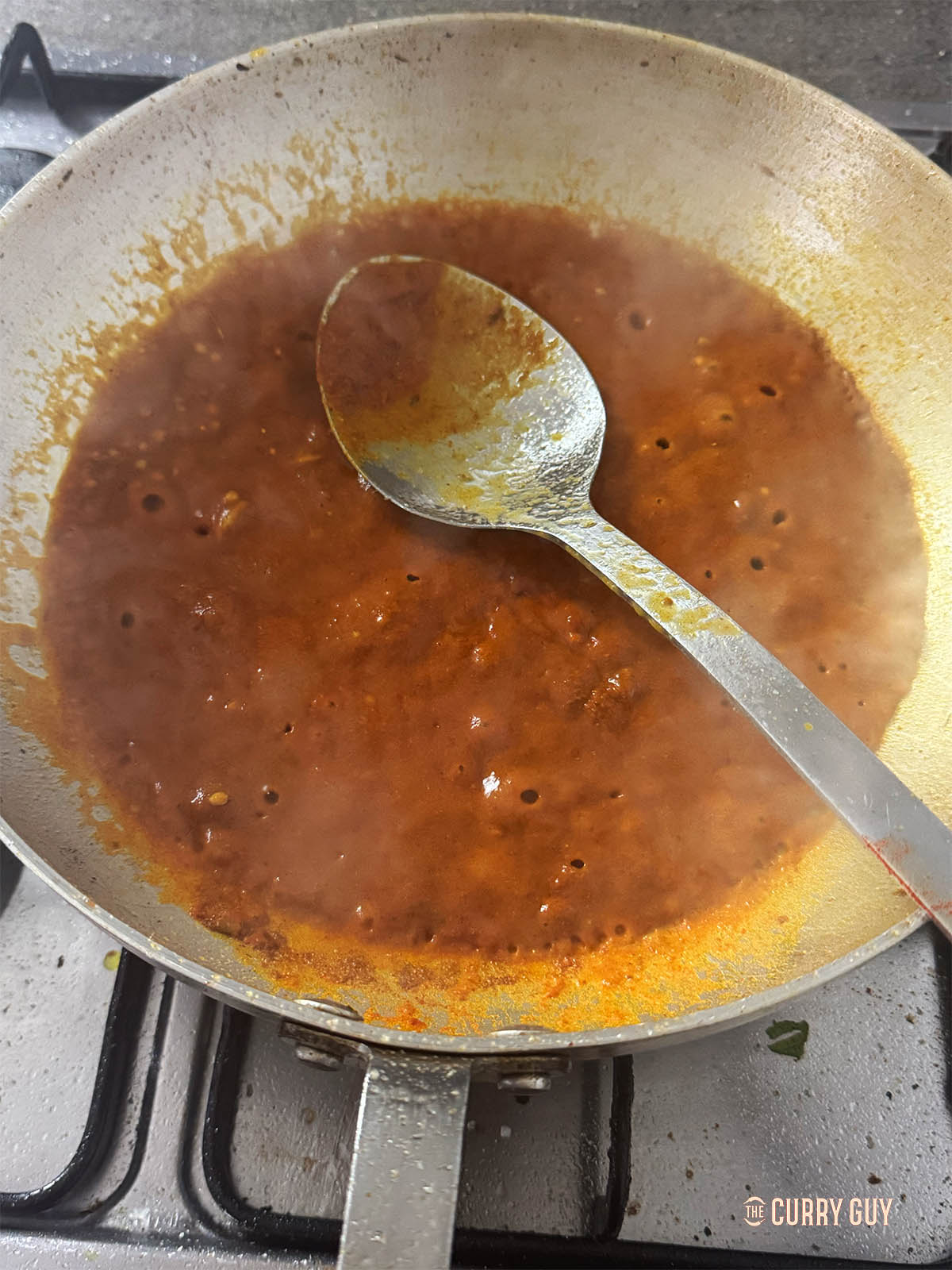 Simmering the base sauce in the pan.