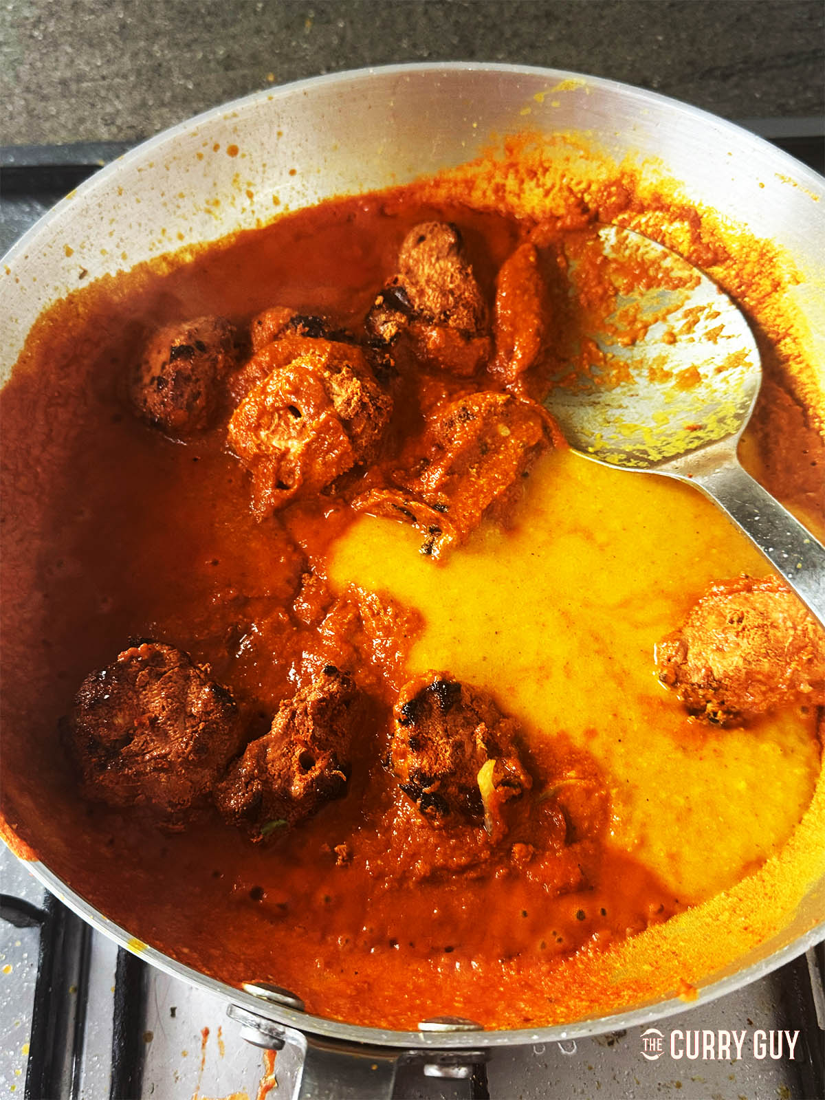 Adding more base sauce and the chicken to the pan.