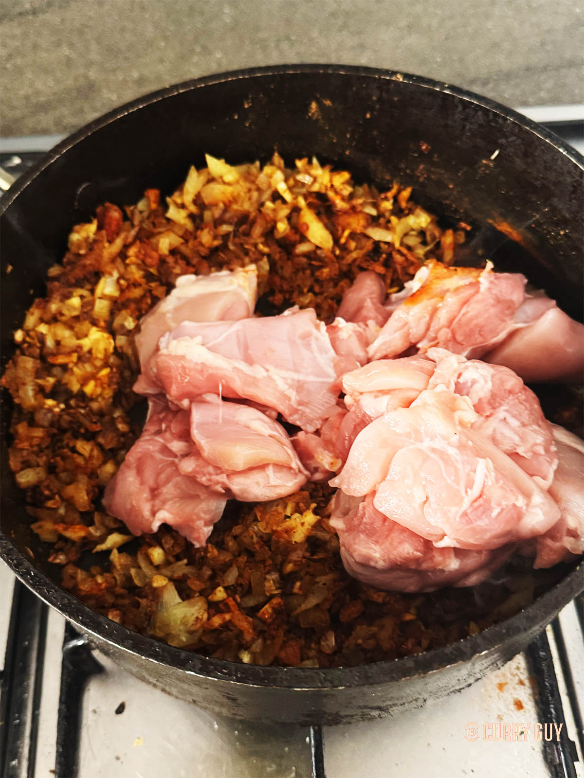 Adding the chicken to the pan.