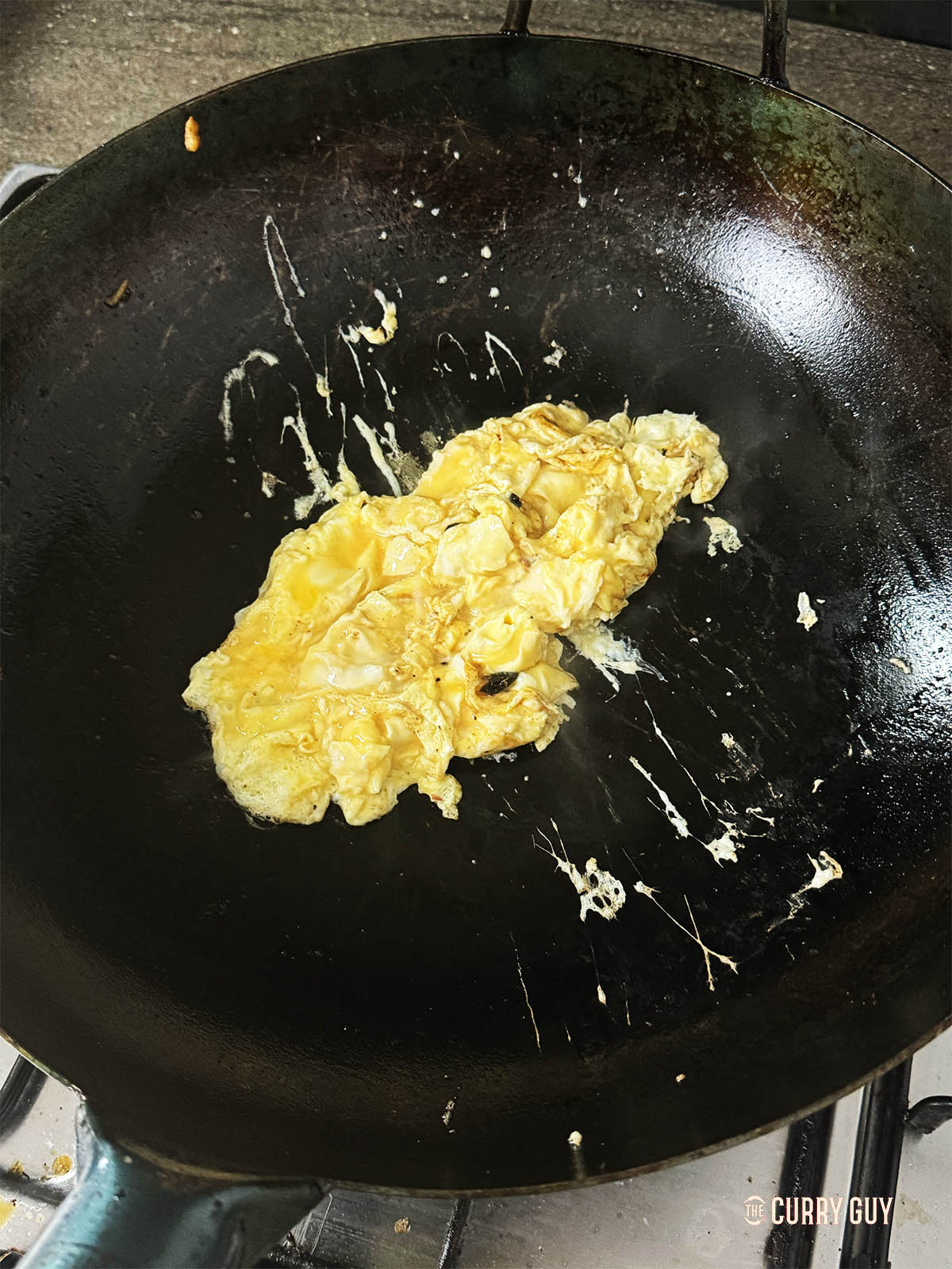 Frying the eggs to scramble in a hot wok.
